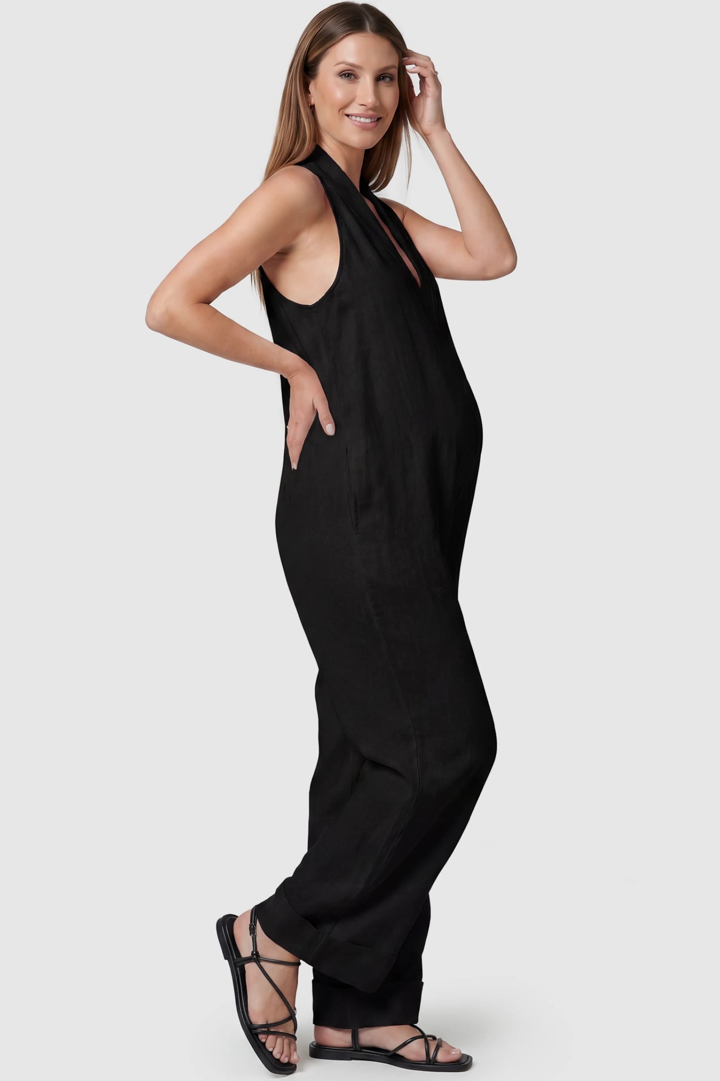 Halter Neck Wide-Leg Maternity Jumpsuit Halter neck wide-leg maternity jumpsuit in black with sleeveless cut, side view on pregnant model