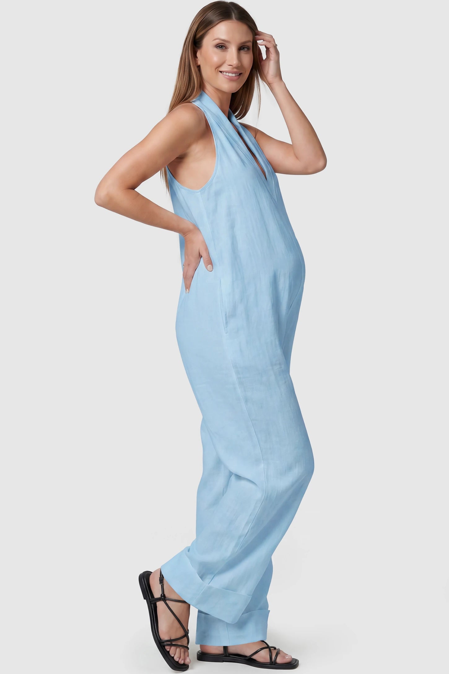 Halter Neck Wide-Leg Maternity Jumpsuit Halter neck wide-leg maternity jumpsuit in blue with sleeveless cut, side view on pregnant model