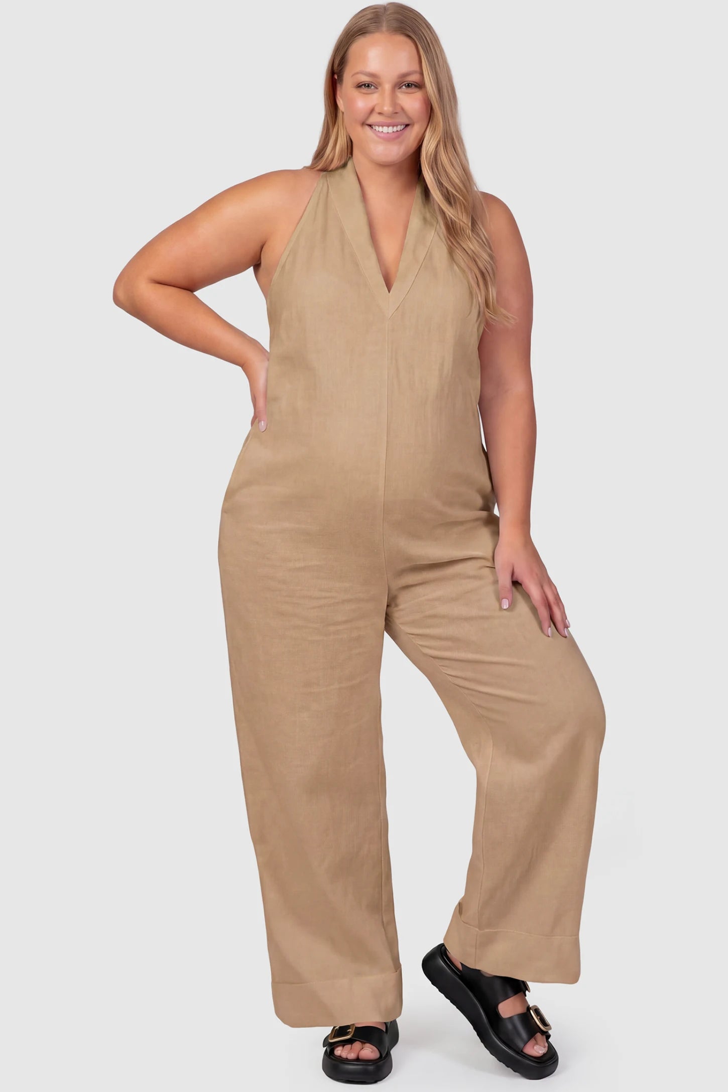 Halter Neck Wide-Leg Maternity Jumpsuit Halter neck wide-leg maternity jumpsuit in camel with chic halter neckline, front view on plus-size model