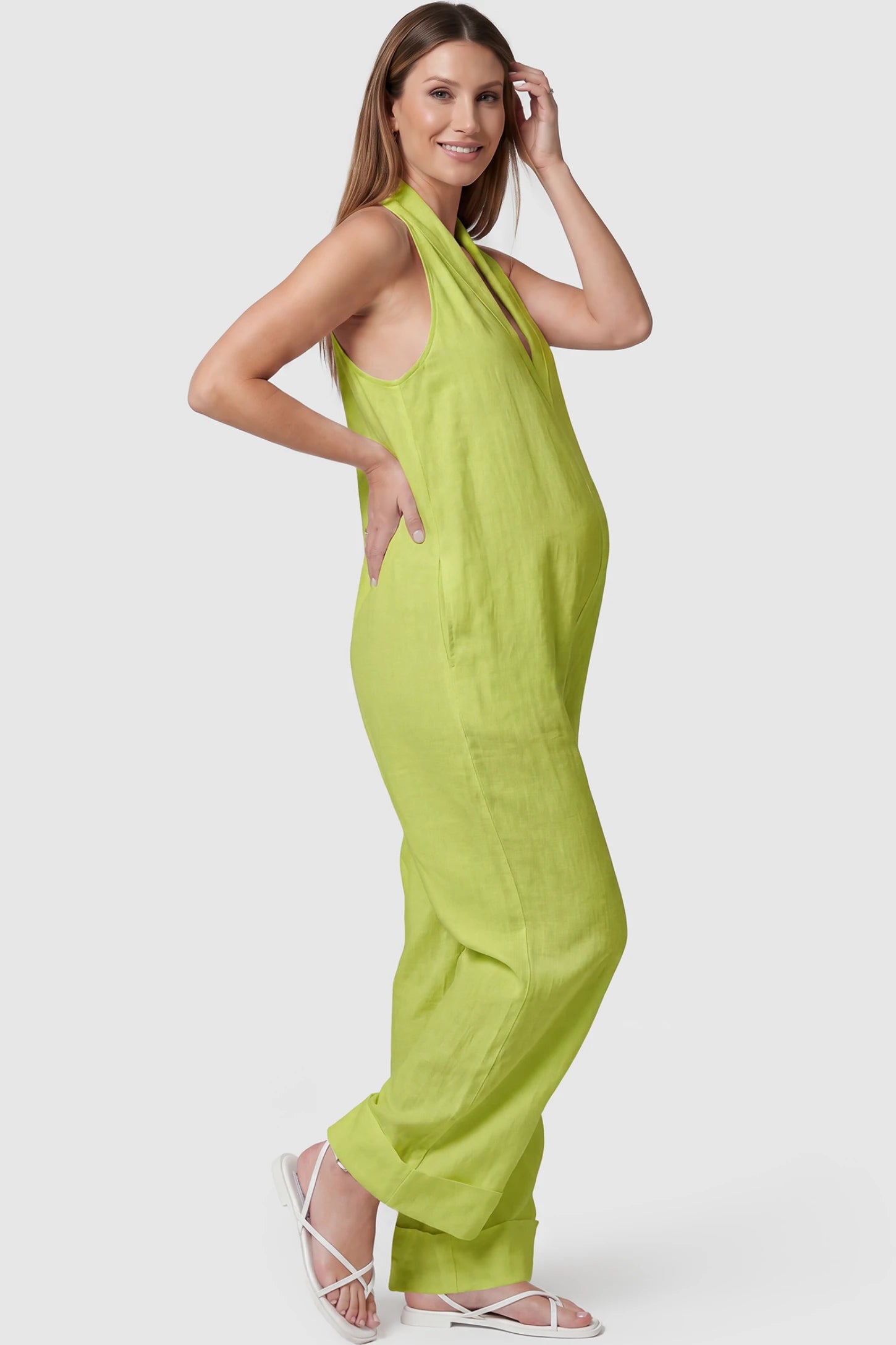 Halter Neck Wide-Leg Maternity Jumpsuit Halter neck wide-leg maternity jumpsuit in green with sleeveless cut, side view on pregnant model