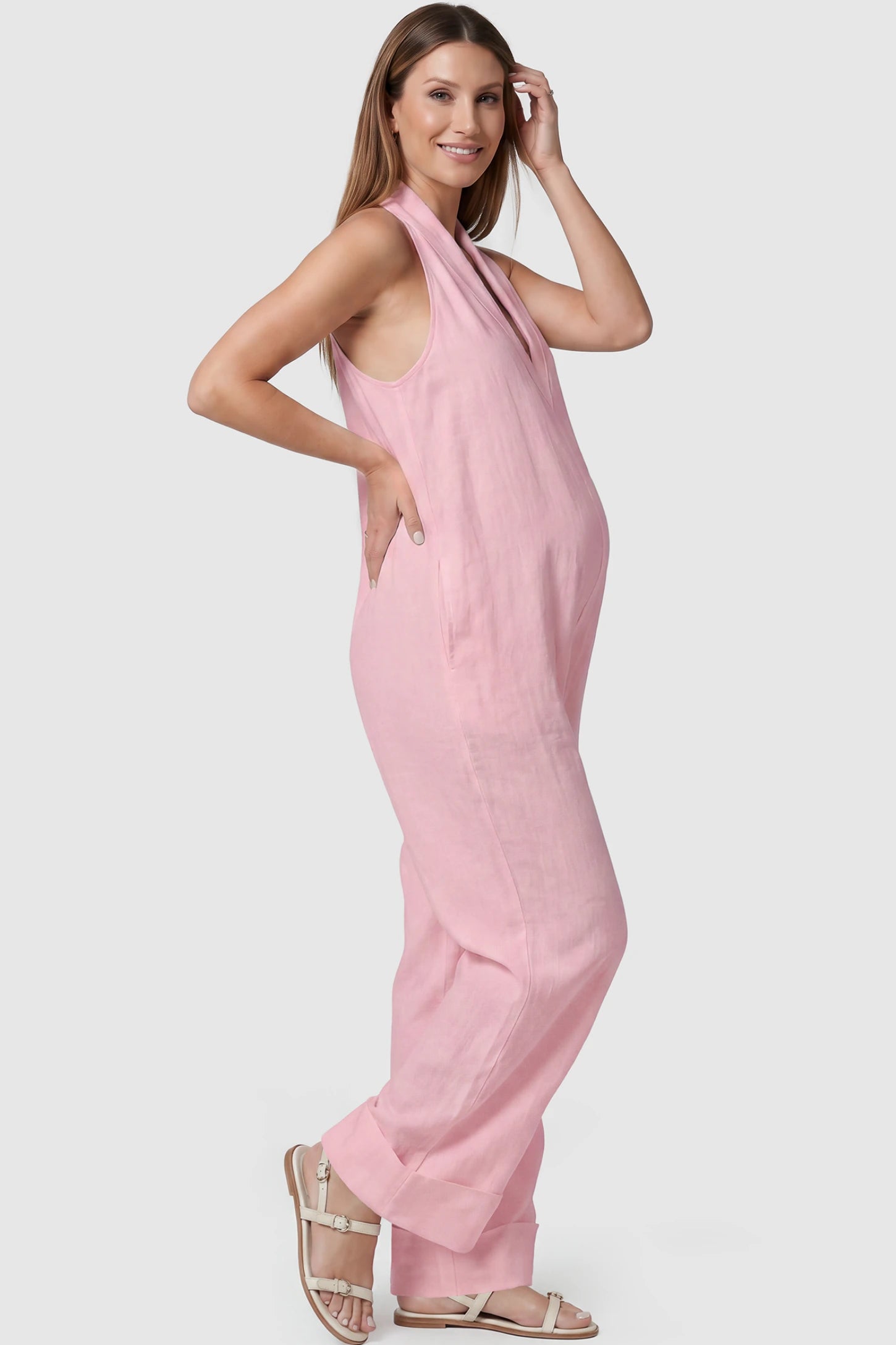Halter Neck Wide-Leg Maternity Jumpsuit Halter neck wide-leg maternity jumpsuit in pink with sleeveless cut, side view on pregnant model