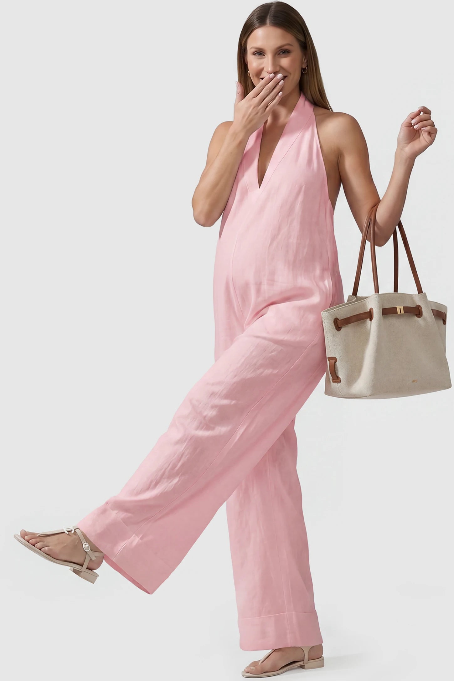 Halter Neck Wide-Leg Maternity Jumpsuit Halter neck wide-leg maternity jumpsuit in pink with chic halter neckline, front view on pregnant model
