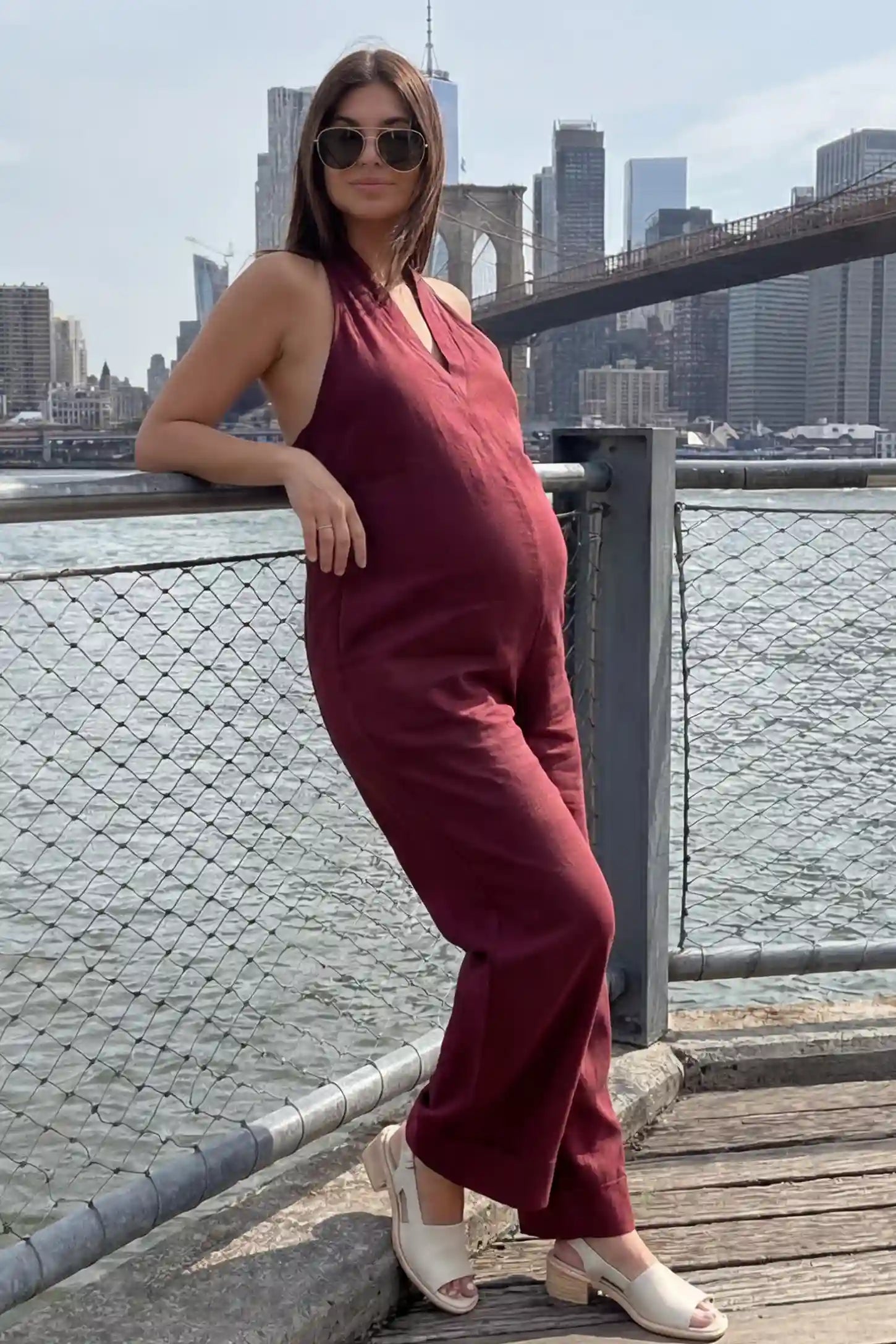 Halter Neck Wide-Leg Maternity Jumpsuit Halter neck wide-leg maternity jumpsuit in wine red with chic halter neckline, side view on pregnant model