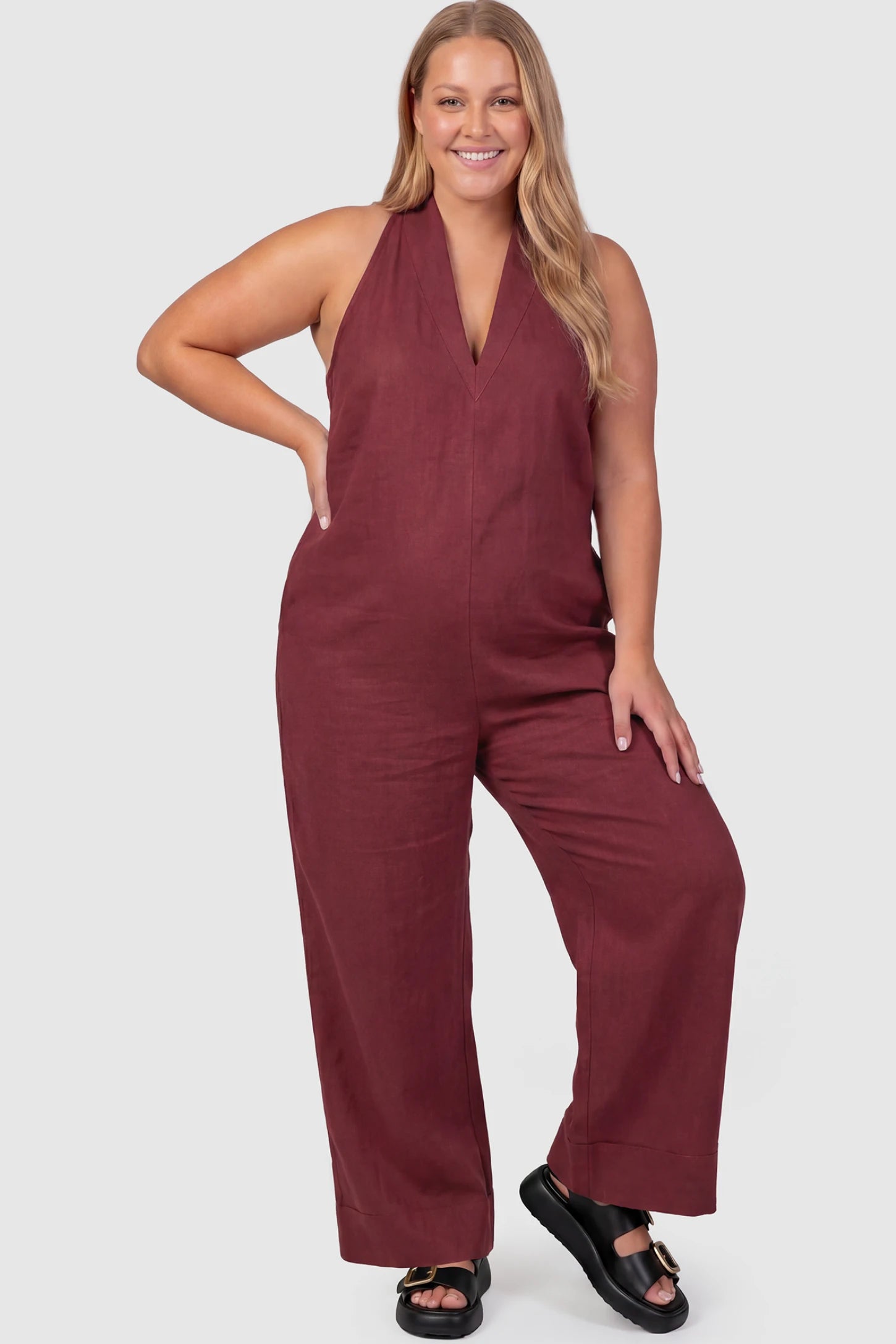 Halter Neck Wide-Leg Maternity Jumpsuit Halter neck wide-leg maternity jumpsuit in wine red with chic halter neckline, front view on plus-size model
