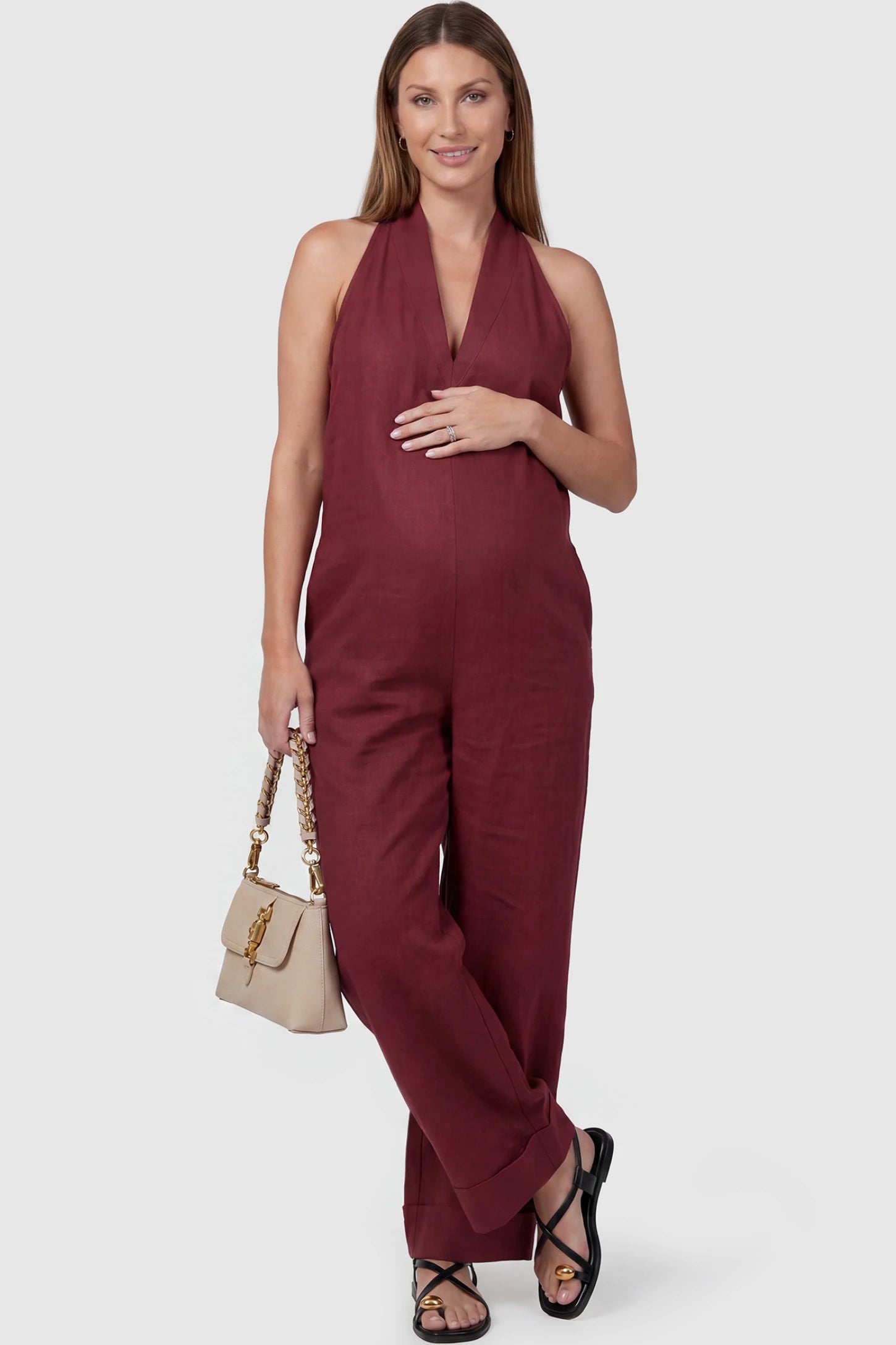 Halter Neck Wide-Leg Maternity Jumpsuit Halter neck wide-leg maternity jumpsuit in wine red with chic halter neckline, front view on pregnant model