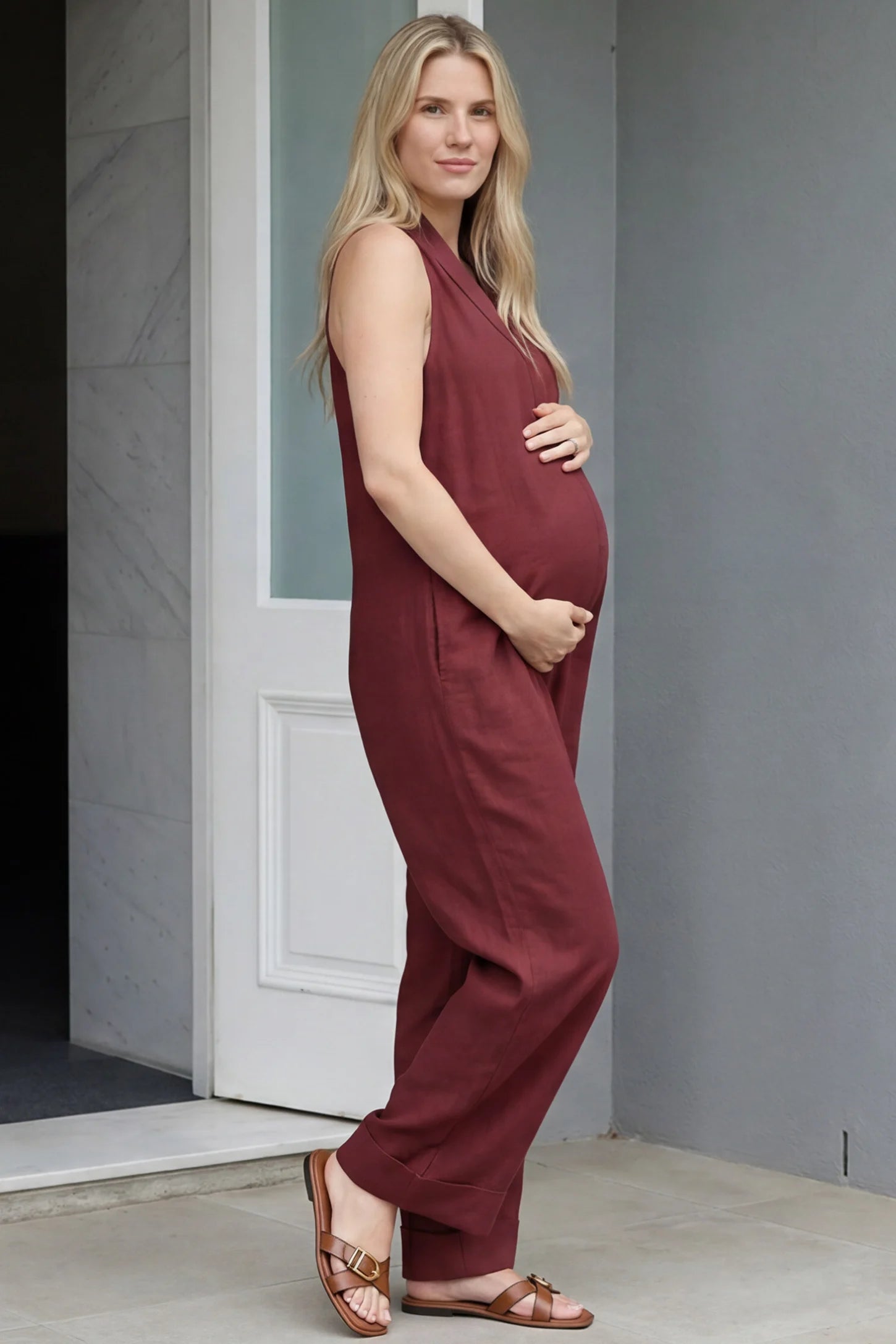 Halter Neck Wide-Leg Maternity Jumpsuit Halter neck wide-leg maternity jumpsuit in wine red with sleeveless cut, side view on pregnant model