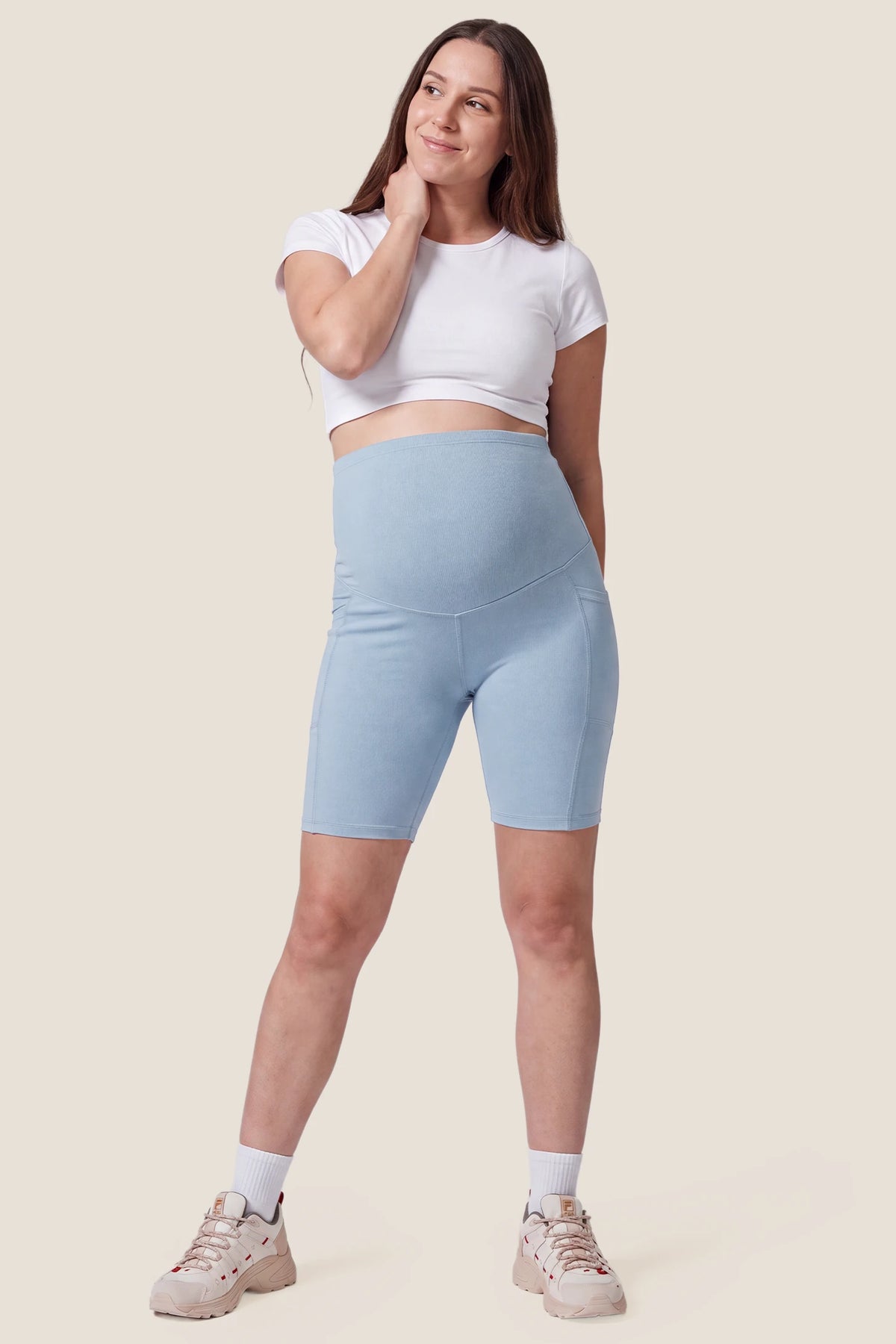 High-Rise Stretch Biker Maternity Shorts High-Rise Stretch Biker Maternity Shorts in Sky Blue featuring 4-way stretch fabric, soft breathable texture, and relaxed maternity athletic style on a pregnant model, full body view.