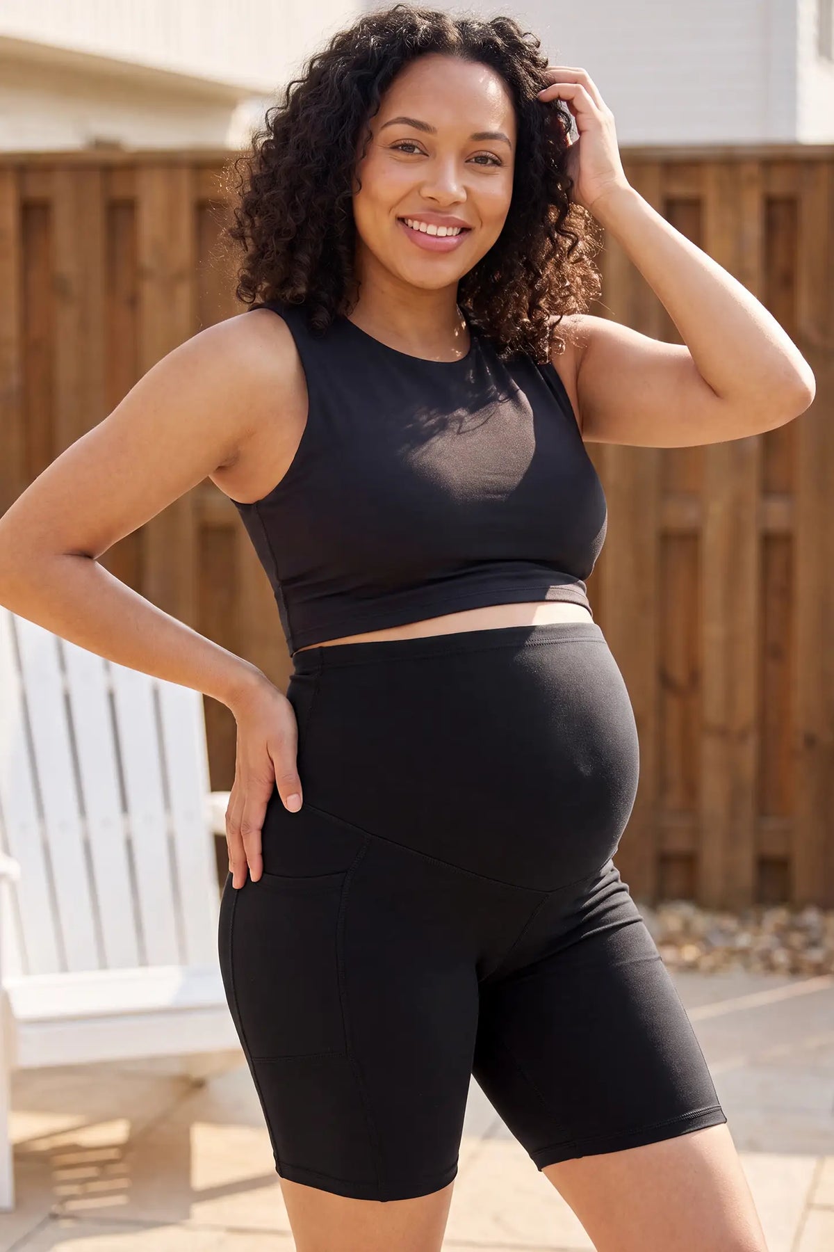High-Rise Stretch Biker Maternity Shorts High-rise stretch biker maternity shorts in black featuring seamless fit, mid-thigh length, and supportive belly panel on pregnant model. front view