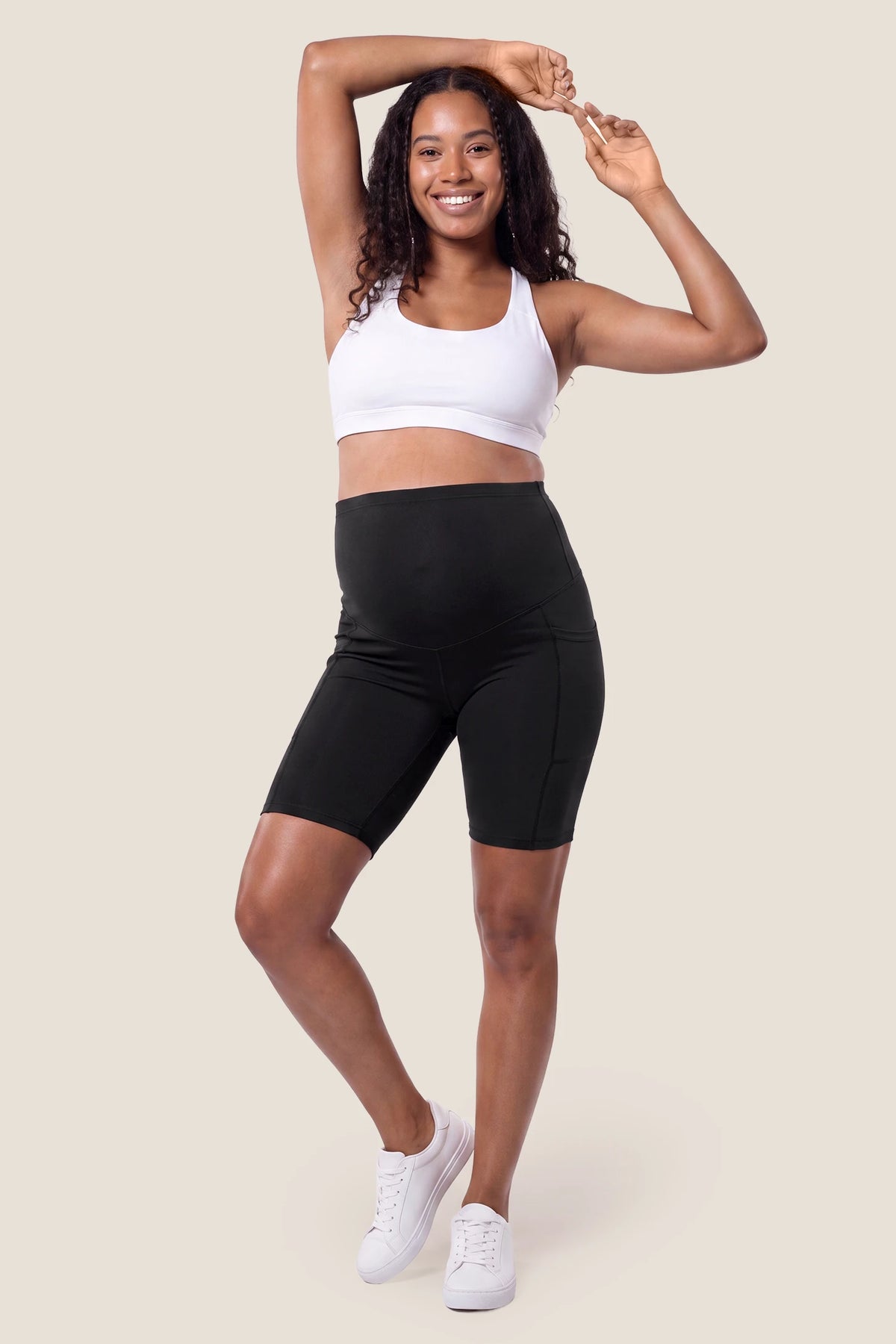 High-Rise Stretch Biker Maternity Shorts High-rise stretch biker maternity shorts in black featuring seamless fit, mid-thigh length, and supportive belly panel on non pregnant model. front view.