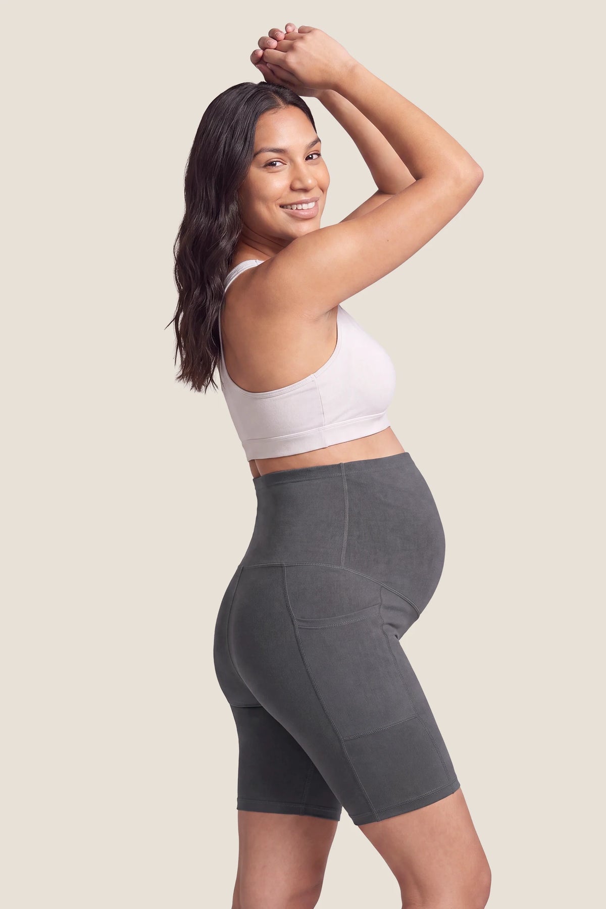 High-Rise Stretch Biker Maternity Shorts High-Rise Stretch Biker Maternity Shorts in Dark Gray featuring seamless belly support, high-stretch jersey feel, and ergonomic maternity contouring on a pregnant model, full body view.