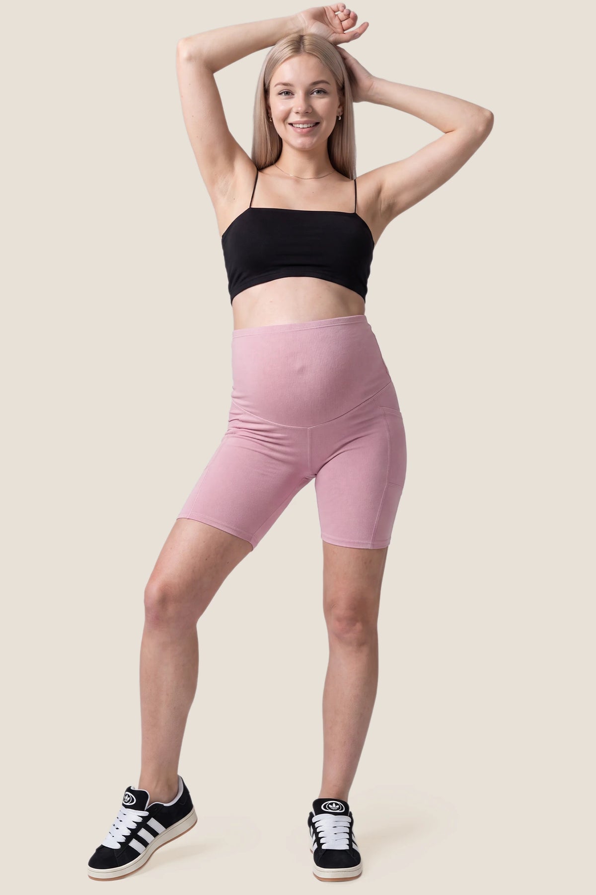 High-Rise Stretch Biker Maternity Shorts High-Rise Stretch Biker Maternity Shorts in Pink featuring soft breathable fabric, full bump support, and athletic activewear style on a pregnant model, full body view.