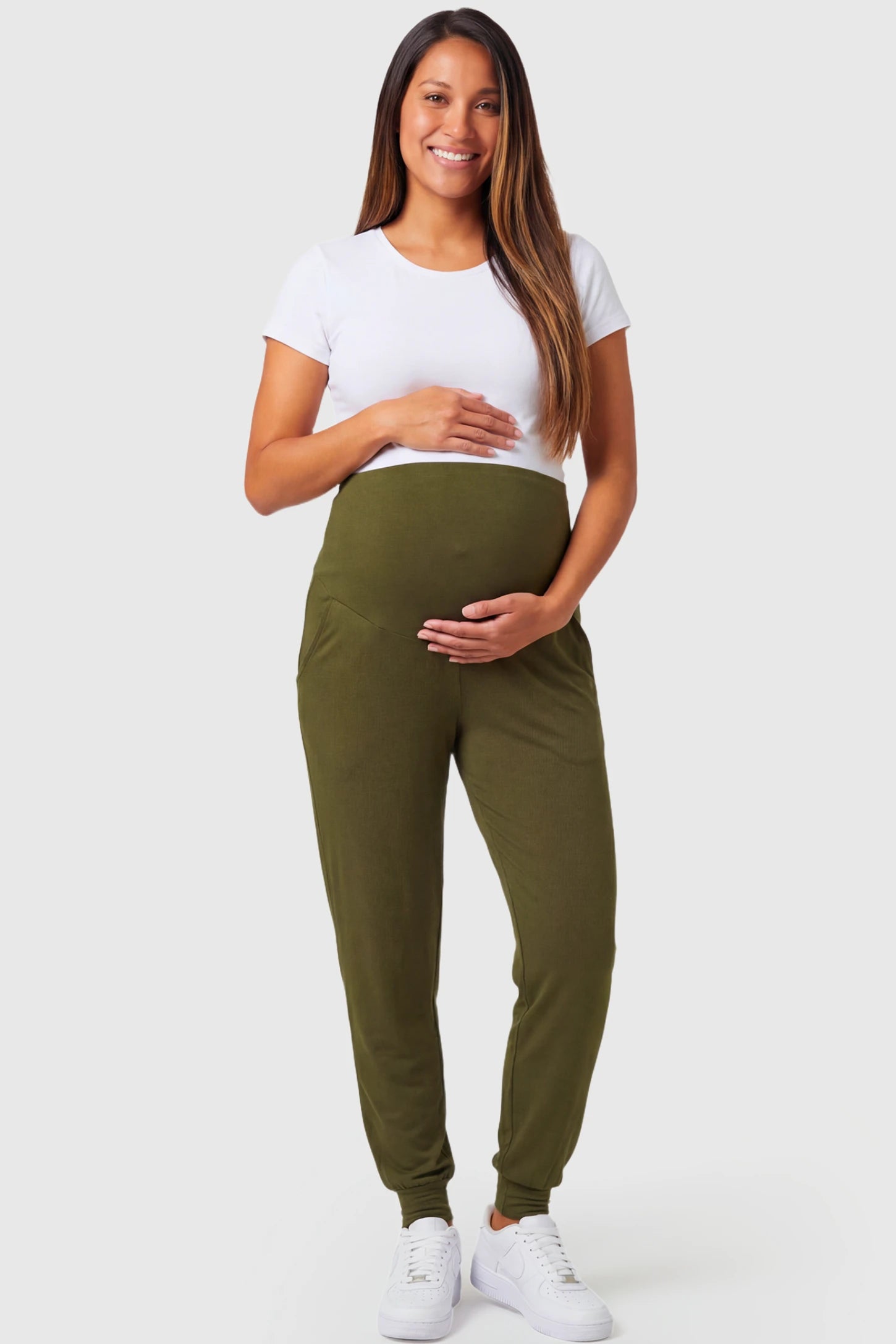 Full-Panel Cuffed Maternity Joggers Full-Panel Cuffed Maternity Joggers in army green featuring high-rise over-the-belly panel, ribbed cuff hem, and side pockets on pregnant model.