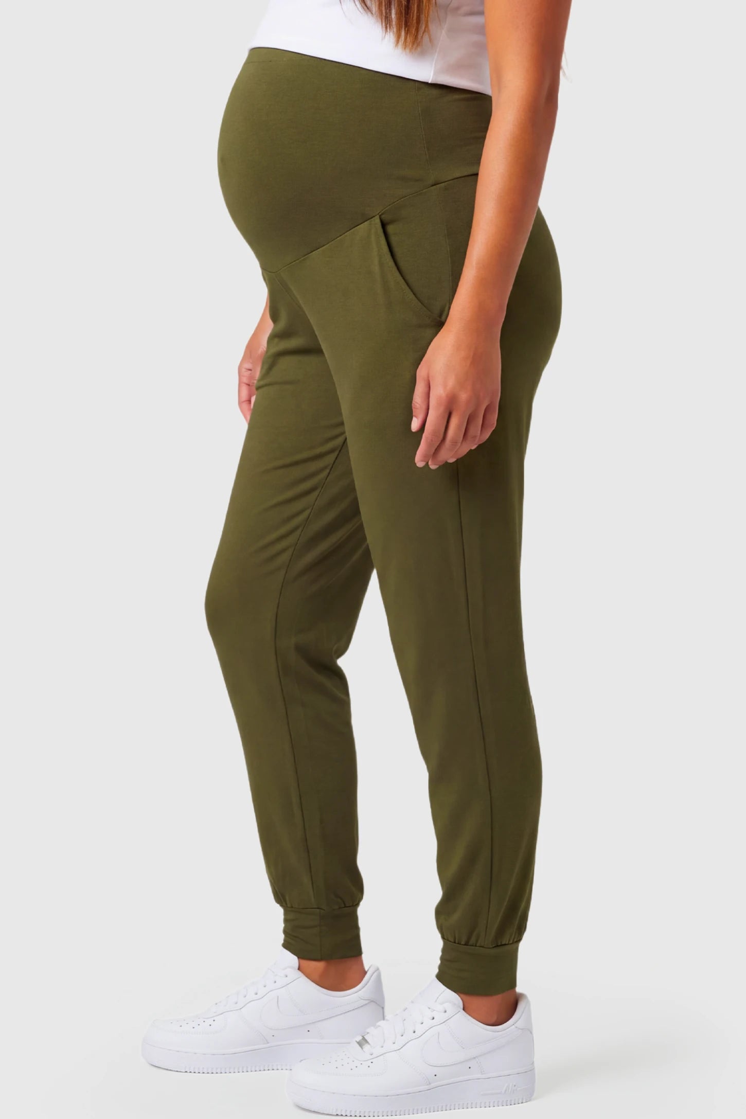 Full-Panel Cuffed Maternity Joggers Full-Panel Cuffed Maternity Joggers in army green featuring high-rise over-the-belly panel, ribbed cuff hem, and side pockets on pregnant model.