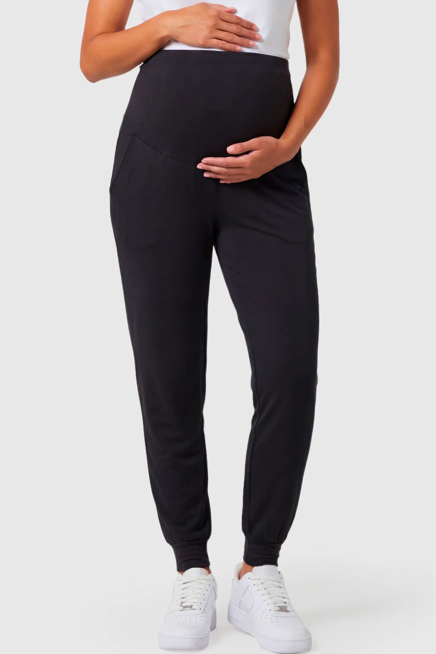 Full-Panel Cuffed Maternity Joggers Full-Panel Cuffed Maternity Joggers in black featuring high-rise over-the-belly panel, ribbed cuff hem, and side pockets on pregnant model.