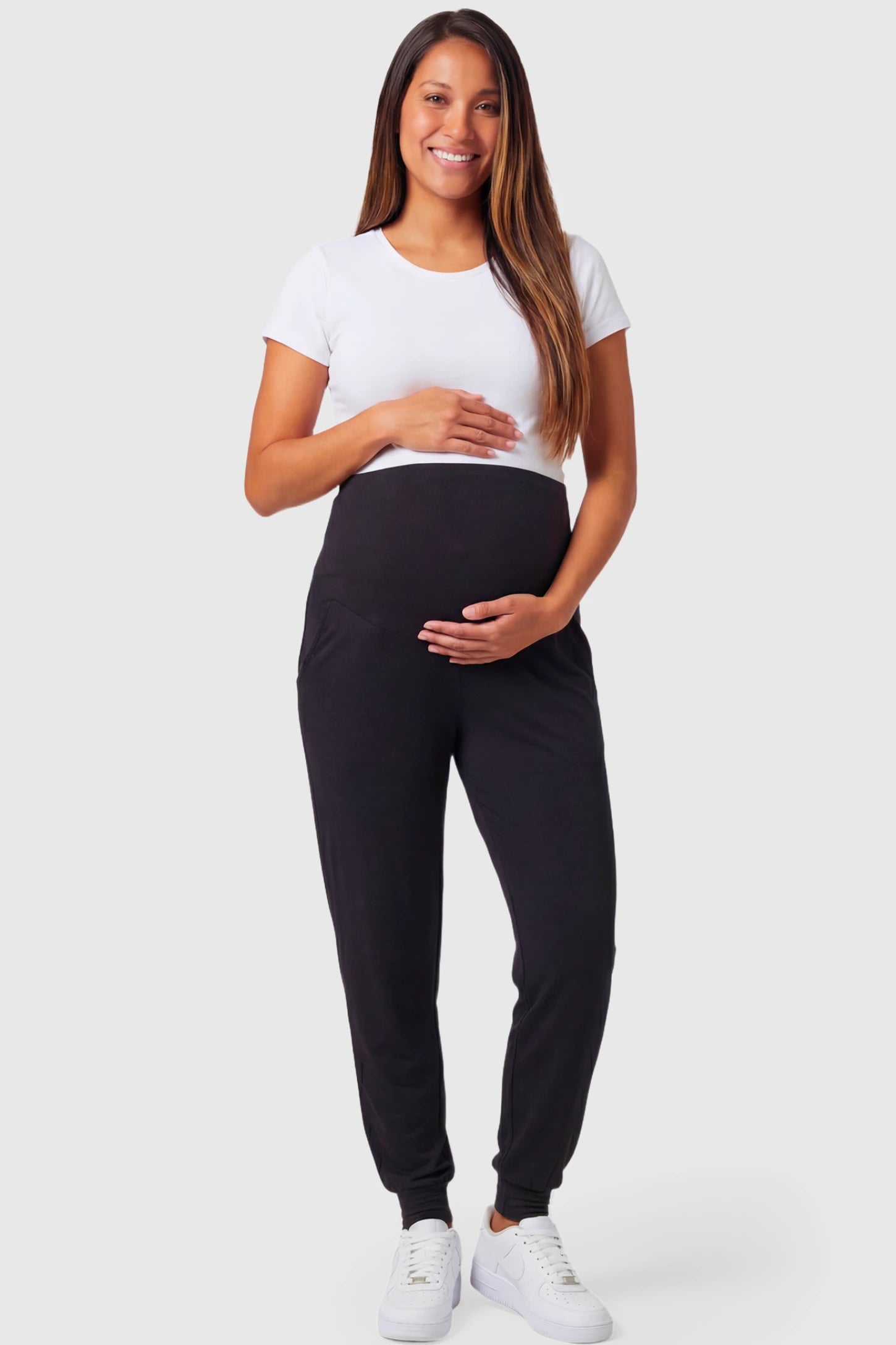 Full-Panel Cuffed Maternity Joggers Full-Panel Cuffed Maternity Joggers in black featuring high-rise over-the-belly panel, ribbed cuff hem, and side pockets on pregnant model.