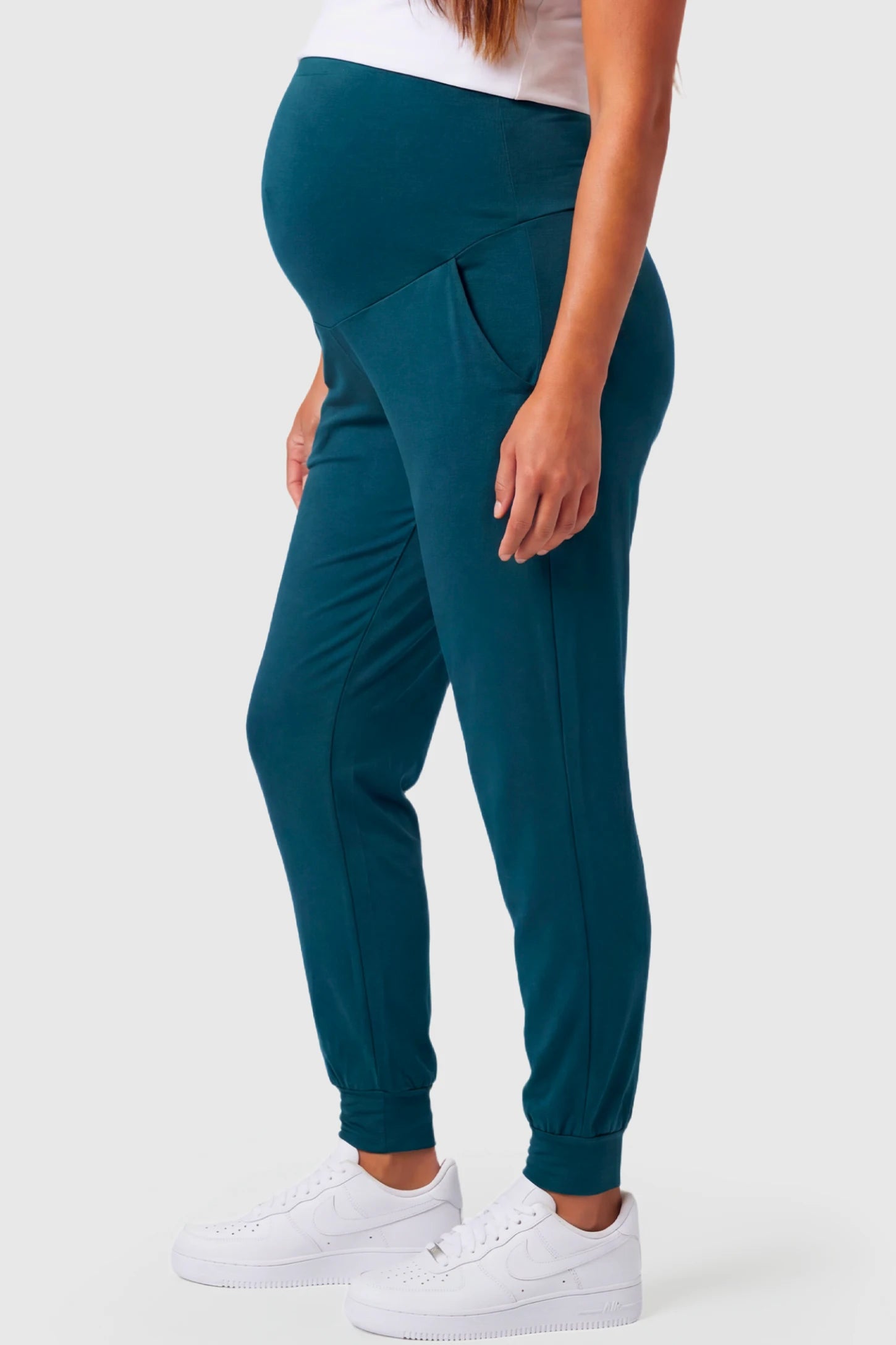 Full-Panel Cuffed Maternity Joggers Full-Panel Cuffed Maternity Joggers in blue featuring high-rise over-the-belly panel, ribbed cuff hem, and side pockets on pregnant model.