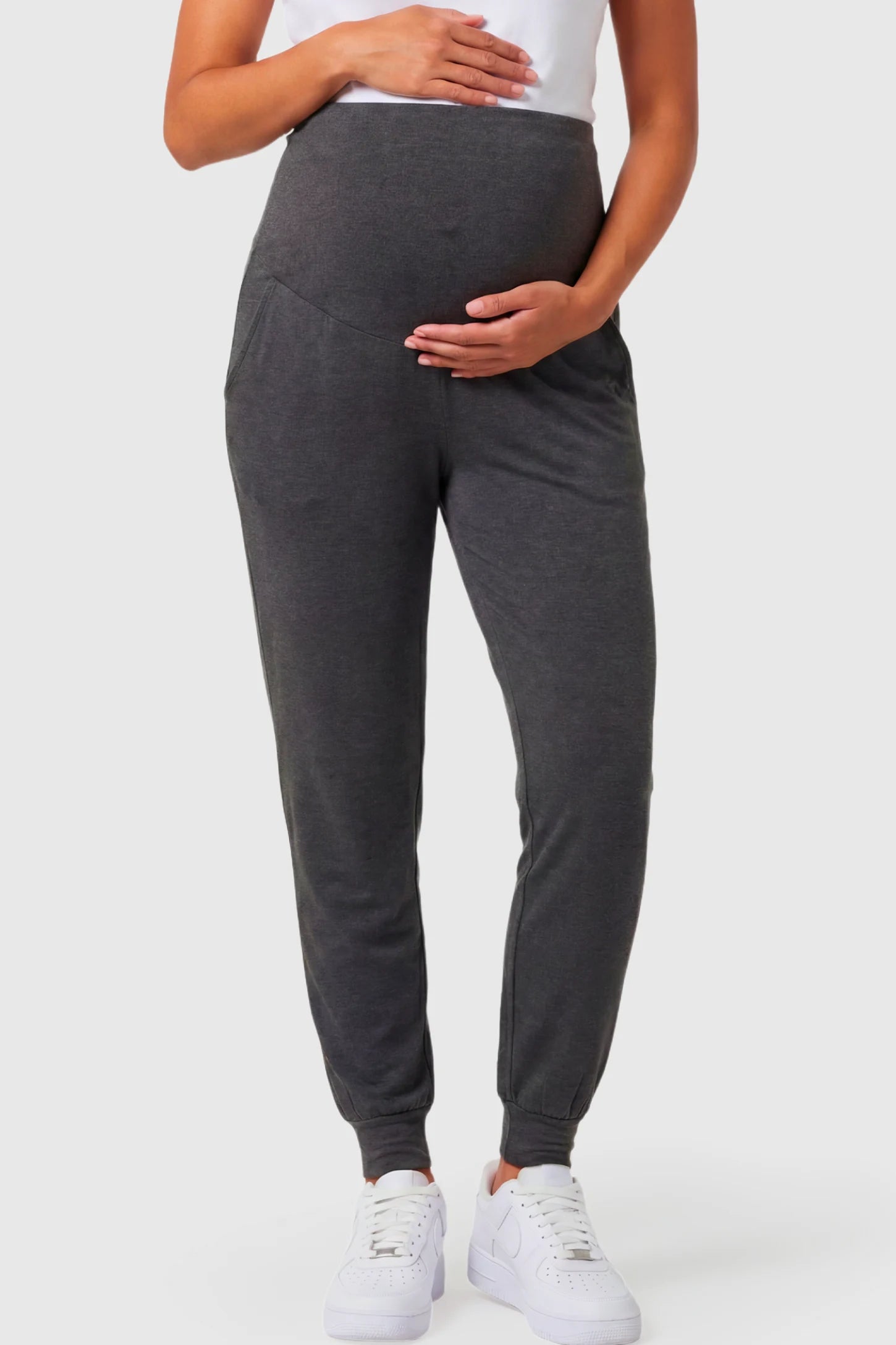 Full-Panel Cuffed Maternity Joggers Full-Panel Cuffed Maternity Joggers in dark gray featuring high-rise over-the-belly panel, ribbed cuff hem, and side pockets on pregnant model.