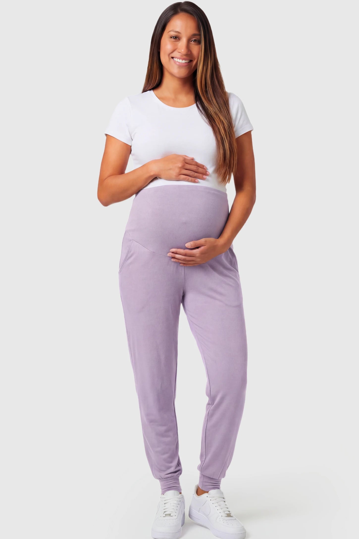 Full-Panel Cuffed Maternity Joggers Full-Panel Cuffed Maternity Joggers in lavender featuring high-rise over-the-belly panel, ribbed cuff hem, and side pockets on pregnant model.