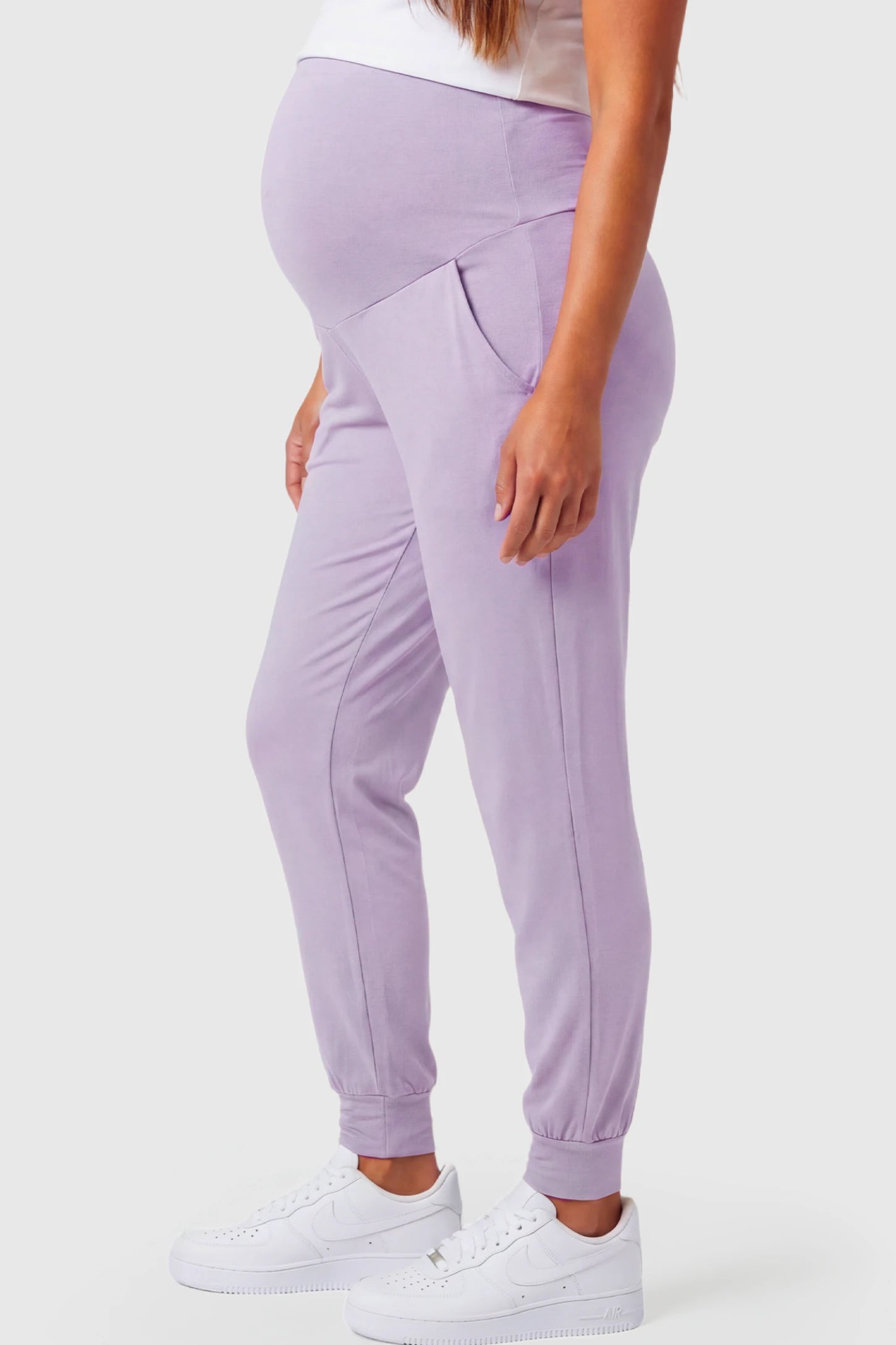 Full-Panel Cuffed Maternity Joggers Full-Panel Cuffed Maternity Joggers in lavender featuring high-rise over-the-belly panel, ribbed cuff hem, and side pockets on pregnant model.