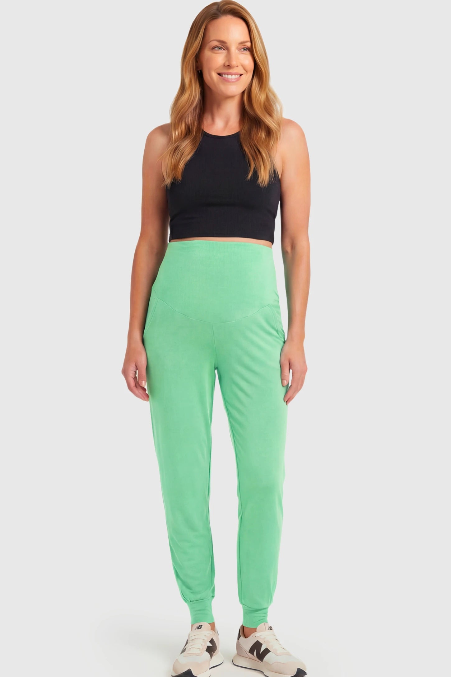 Full-Panel Cuffed Maternity Joggers Full-Panel Cuffed Maternity Joggers in light green featuring high-rise over-the-belly panel, ribbed cuff hem, and side pockets on non pregnant model.