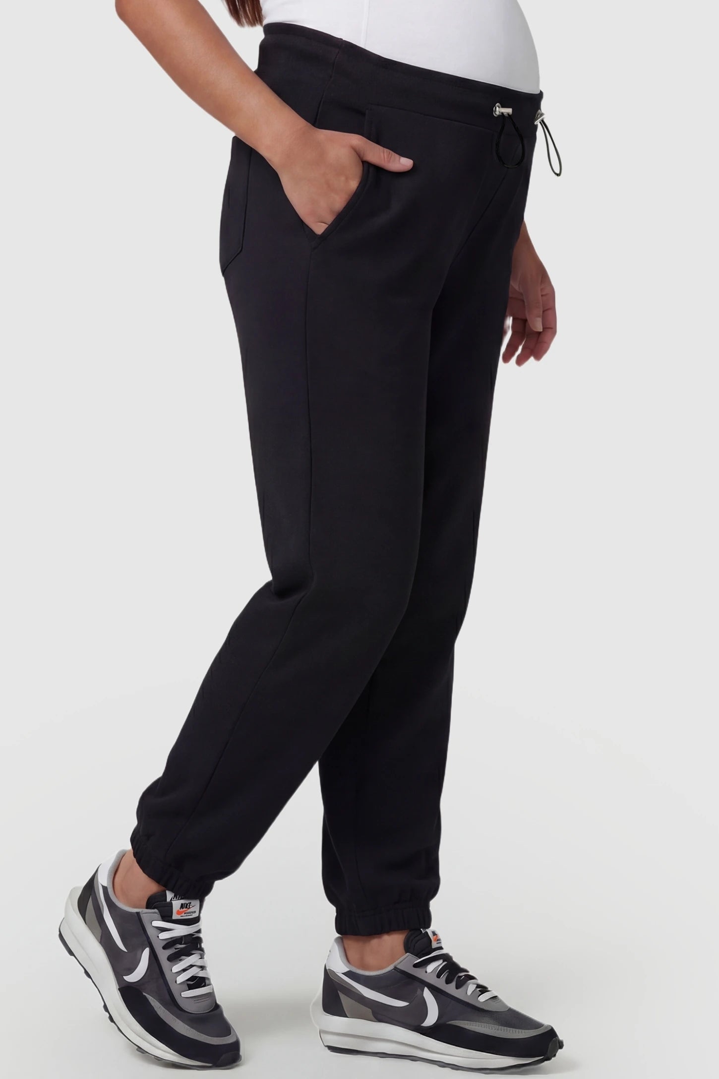 High-Rise Drawstring Waist Loose Fit Jogger Maternity Pants High-rise drawstring waist loose fit jogger maternity pants in black with side pockets, side view on pregnant model