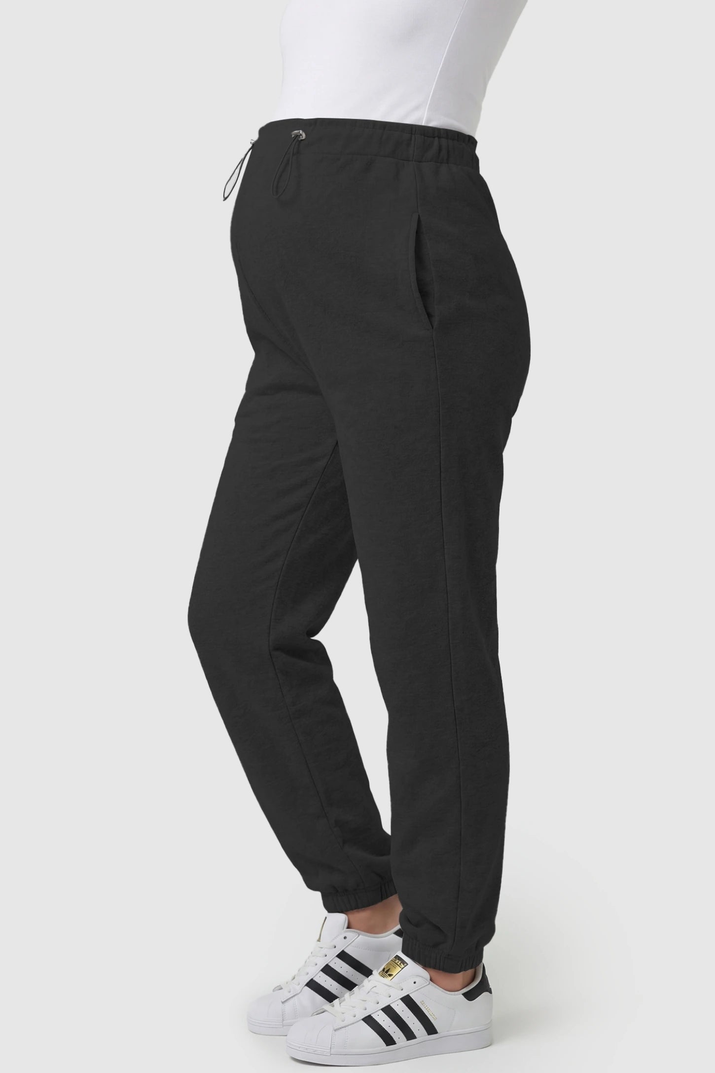 High-Rise Drawstring Waist Loose Fit Jogger Maternity Pants High-rise drawstring waist loose fit jogger maternity pants in black with side pockets, side view on pregnant model