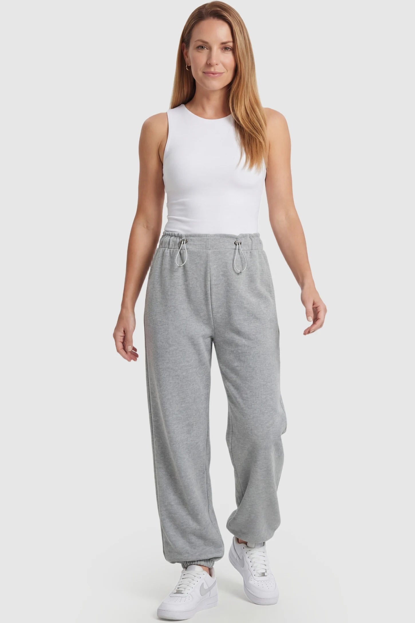 High-Rise Drawstring Waist Loose Fit Jogger Maternity Pants High-rise drawstring waist loose fit jogger maternity pants in gray with relaxed fit & adjustable drawstring, full body on postpartum model