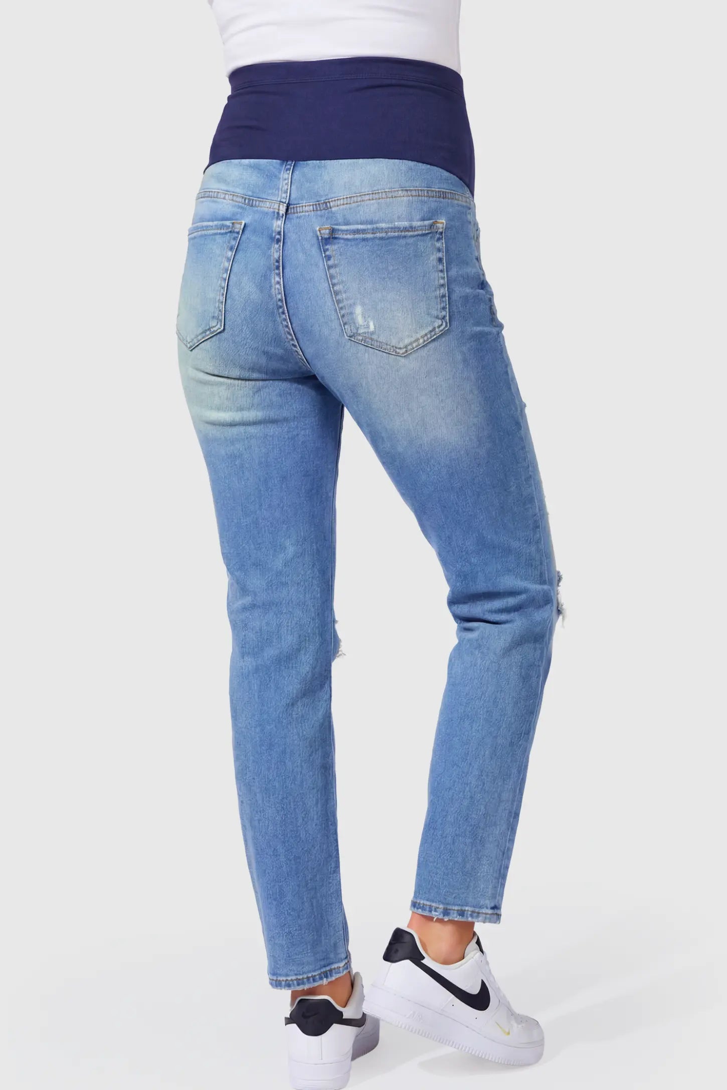 Raw Hem Ankle Straight Leg Maternity Jeans Raw Hem Ankle Straight Leg Maternity Jeans in blue denim featuring high-rise over-the-belly panel and knee-open distressing on pregnant model.