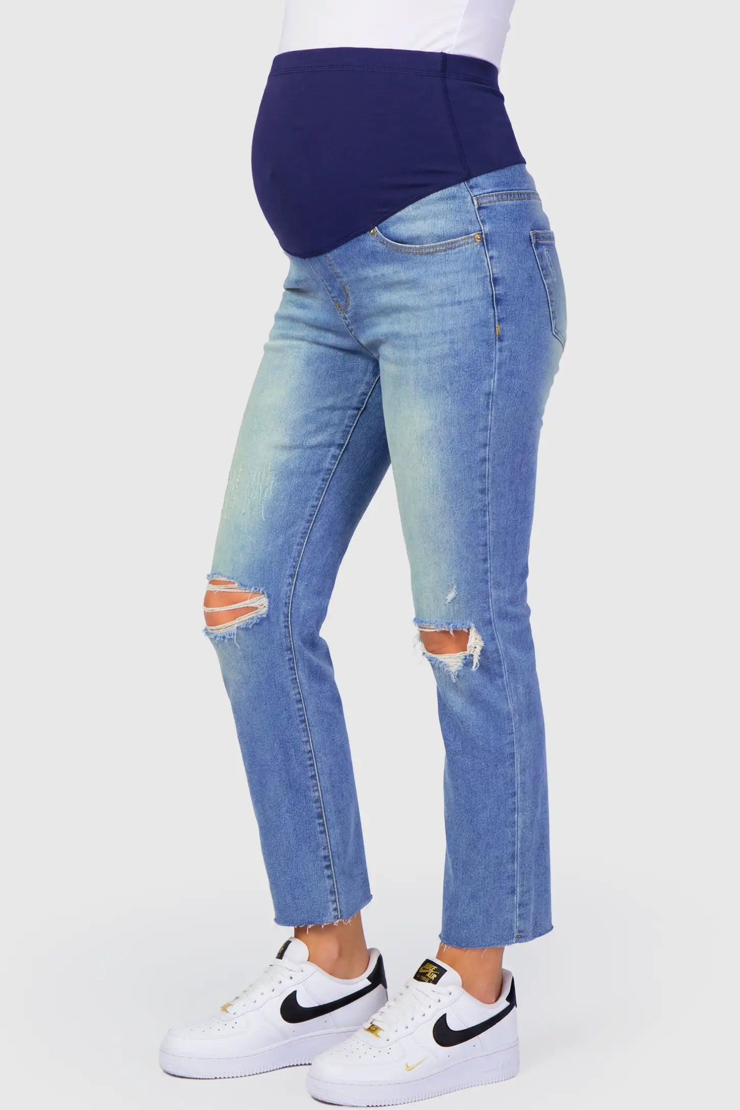 Raw Hem Ankle Straight Leg Maternity Jeans Raw Hem Ankle Straight Leg Maternity Jeans in blue denim featuring high-rise over-the-belly panel and knee-open distressing on pregnant model.