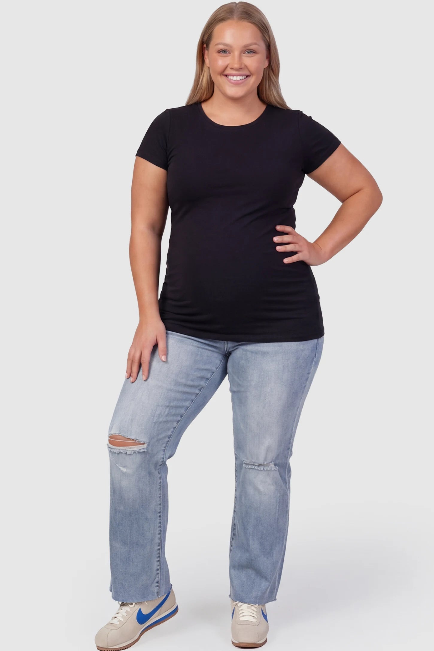 Knee Slit Wide Leg Maternity Jeans Knee slit wide leg maternity jeans in blue with distressed knee slit detail, front view on plus-size model
