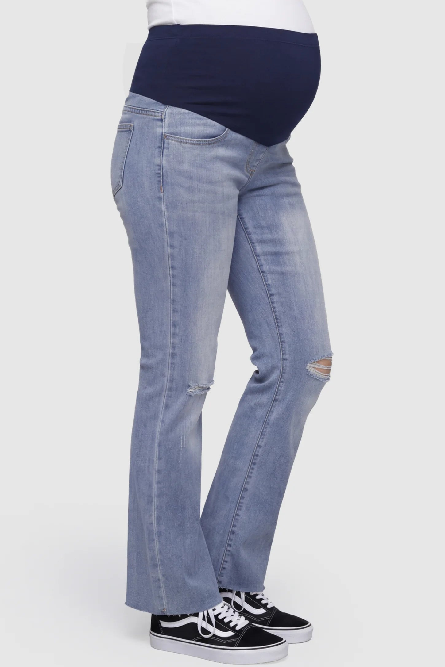 Knee Slit Wide Leg Maternity Jeans Knee slit wide leg maternity jeans in blue with distressed knee slit detail and side pocket, side view on pregnant model