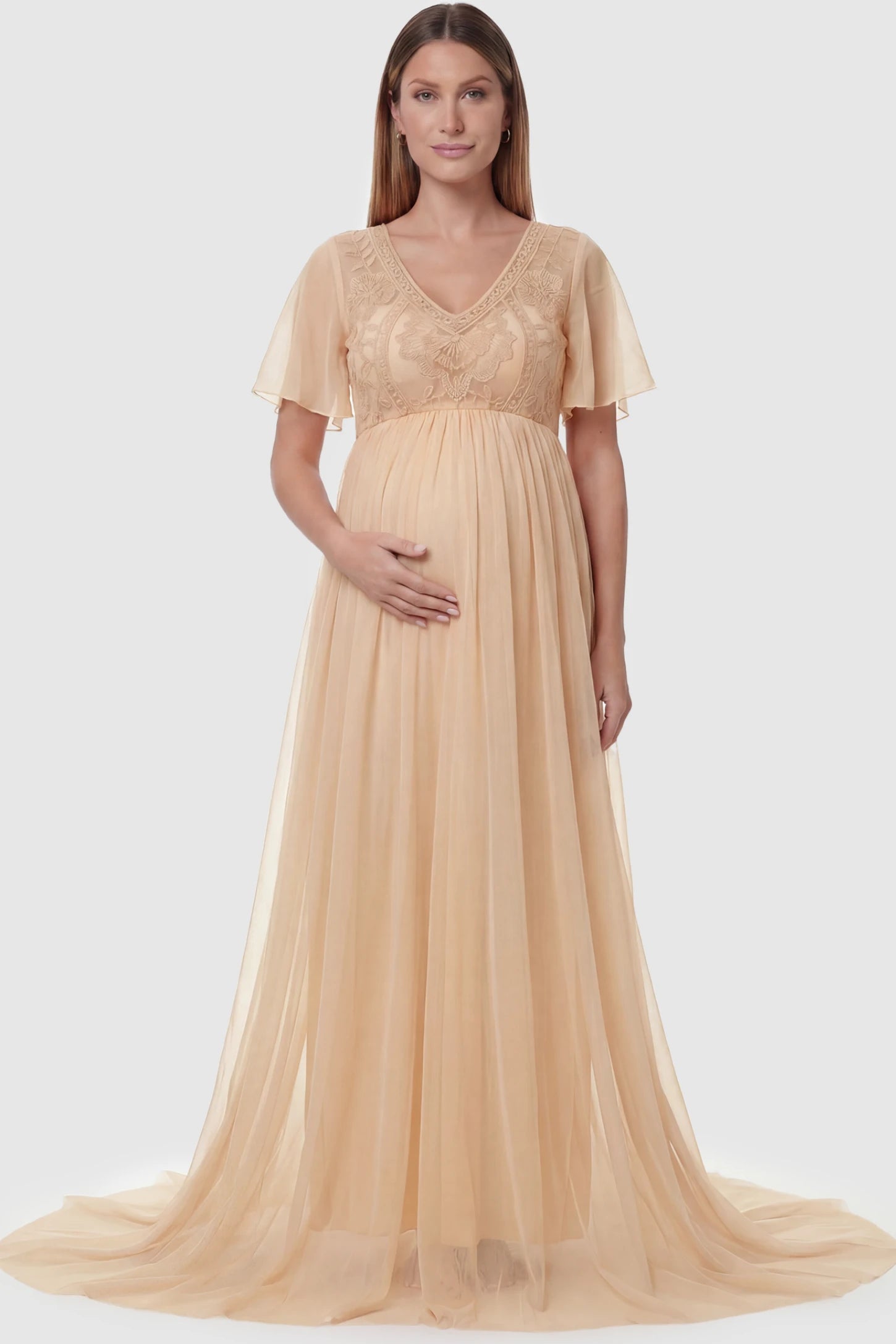 Lace embroidered short flutter sleeve maxi maternity gown in apricot featuring delicate lace embroidery in front view on a pregnant model