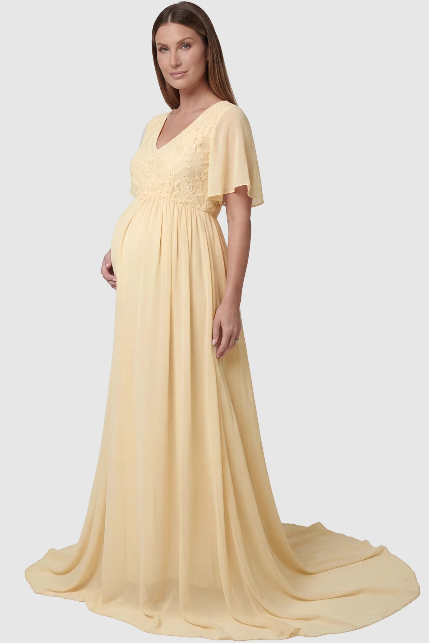 Lace Embroidered Short Flutter Sleeve Maternity Gown Lace embroidered short flutter sleeve maternity gown in apricot with delicate lace embroidery & flutter sleeves, side view on pregnant model