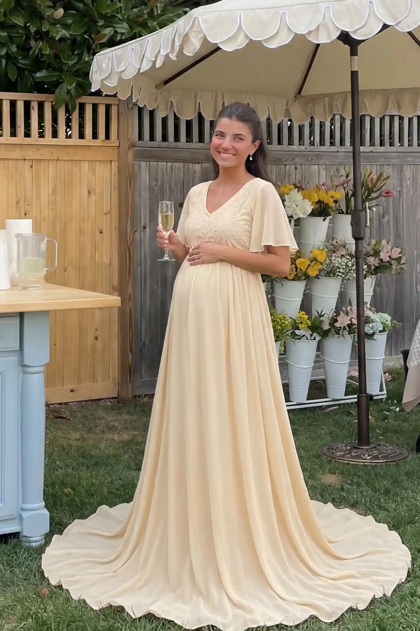 Lace Embroidered Short Flutter Sleeve Maternity Gown Lace embroidered short flutter sleeve maternity gown in apricot with delicate lace embroidery & flutter sleeves, front view on pregnant model