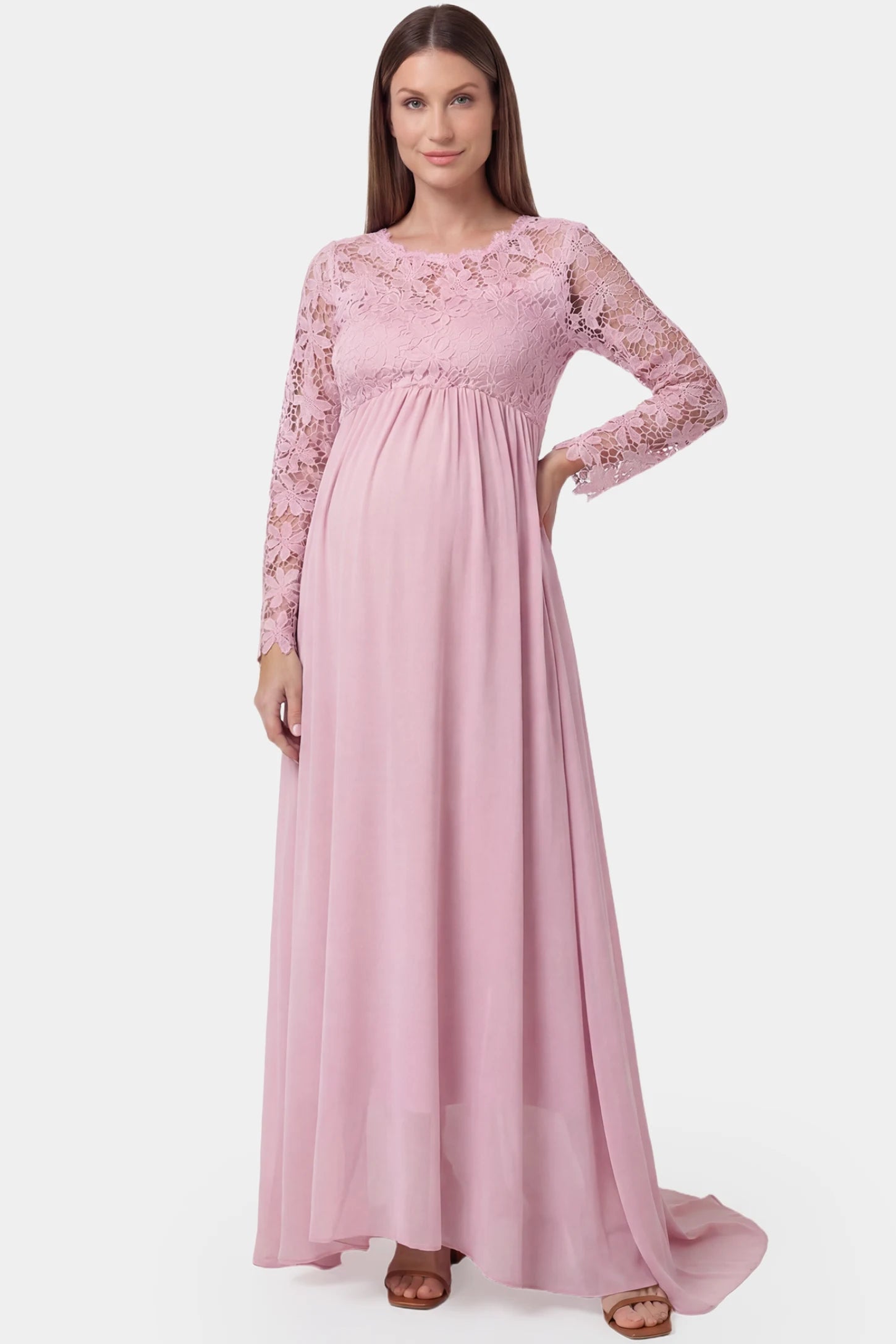 Lace long sleeve full skirt maxi maternity dress in pink featuring empire waist in full body front view on a pregnant model