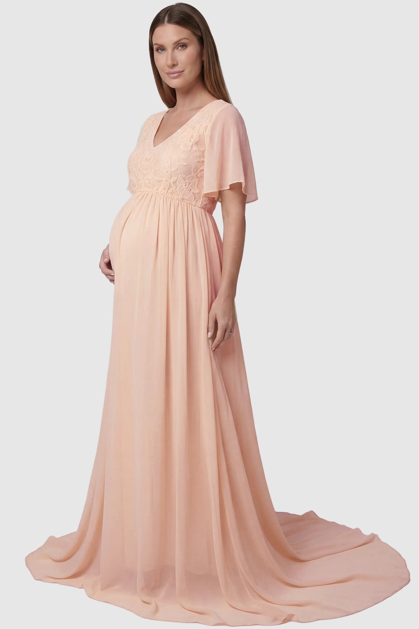 Lace Embroidered Short Flutter Sleeve Maternity Gown Lace embroidered short flutter sleeve maternity gown in pink with delicate lace embroidery & flutter sleeves, side view on pregnant model