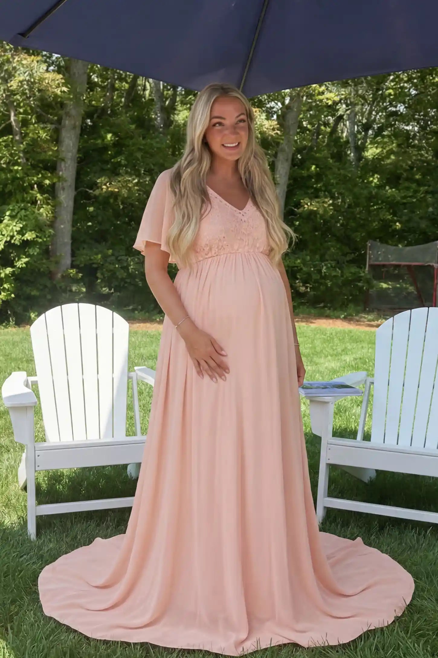 Lace Embroidered Short Flutter Sleeve Maternity Gown Lace embroidered short flutter sleeve maternity gown in pink with delicate lace embroidery & flutter sleeves, front view on pregnant model