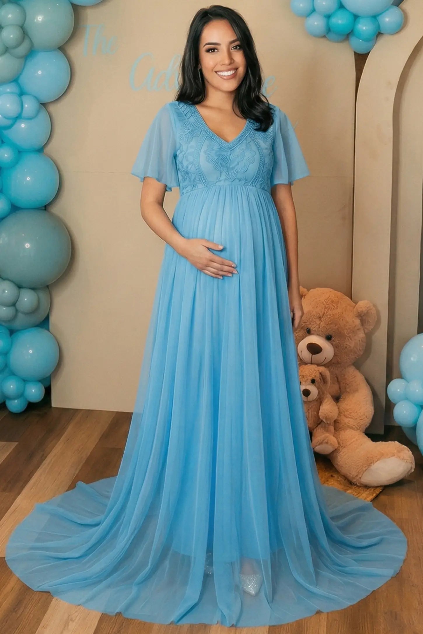 Lace Embroidered Short Flutter Sleeve Maxi Maternity Gown Lace embroidered short flutter sleeve maxi maternity gown in sky blue with embroidered lace and long-train, full body on a UGC model