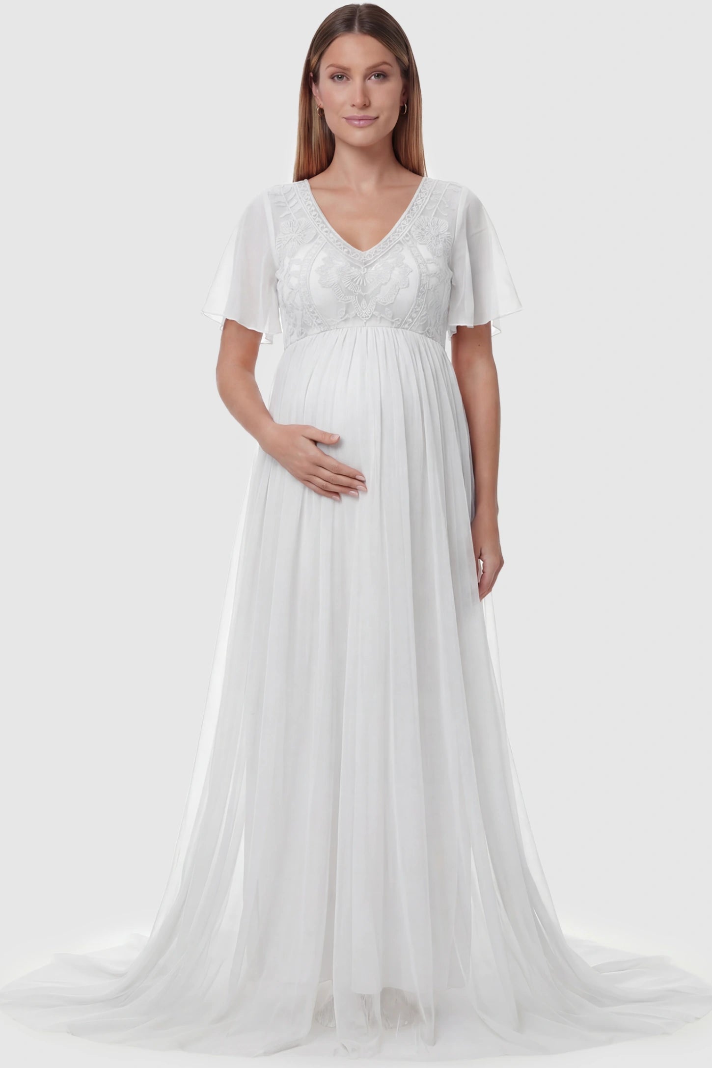 Lace Embroidered Short Flutter Sleeve Maxi Maternity Gown Lace embroidered short flutter sleeve maxi maternity gown in White featuring delicate lace embroidery in front view on a pregnant model