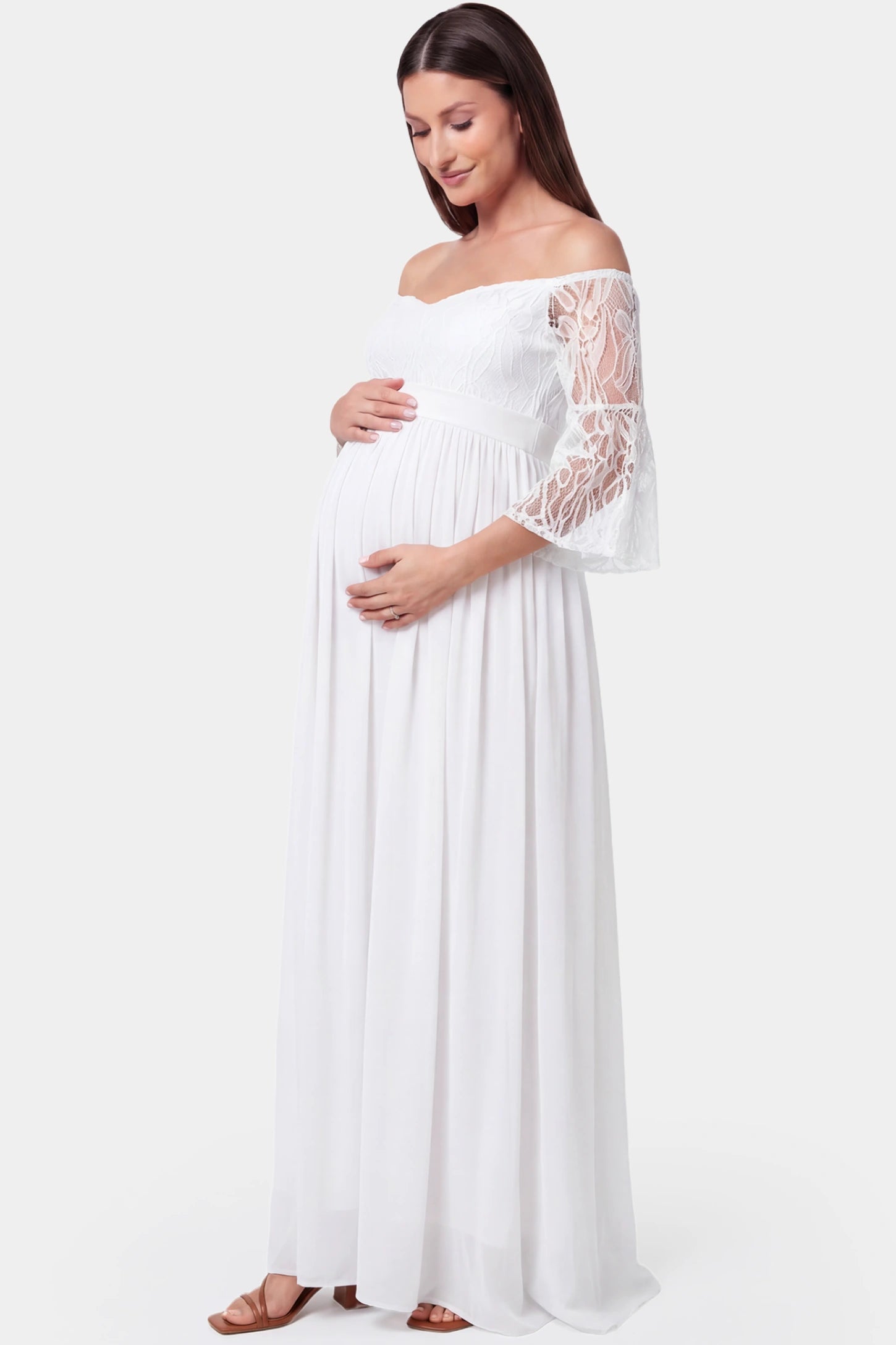 Lace-Spliced Off-Shoulder Flutter Sleeve Maxi Maternity Dress Lace-spliced off-shoulder flutter sleeve maxi maternity dress in white featuring high-waisted flowing skirt in side view on a pregnant model