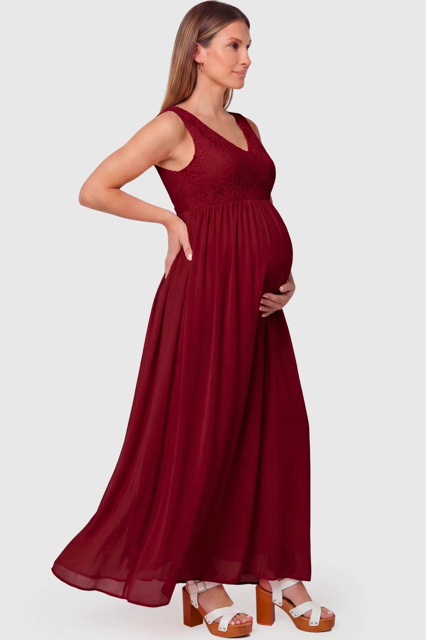 Lace Empire Waist Maternity Maxi Dress in wine red featuring V-neckline and flowing relaxed fit on pregnant model.