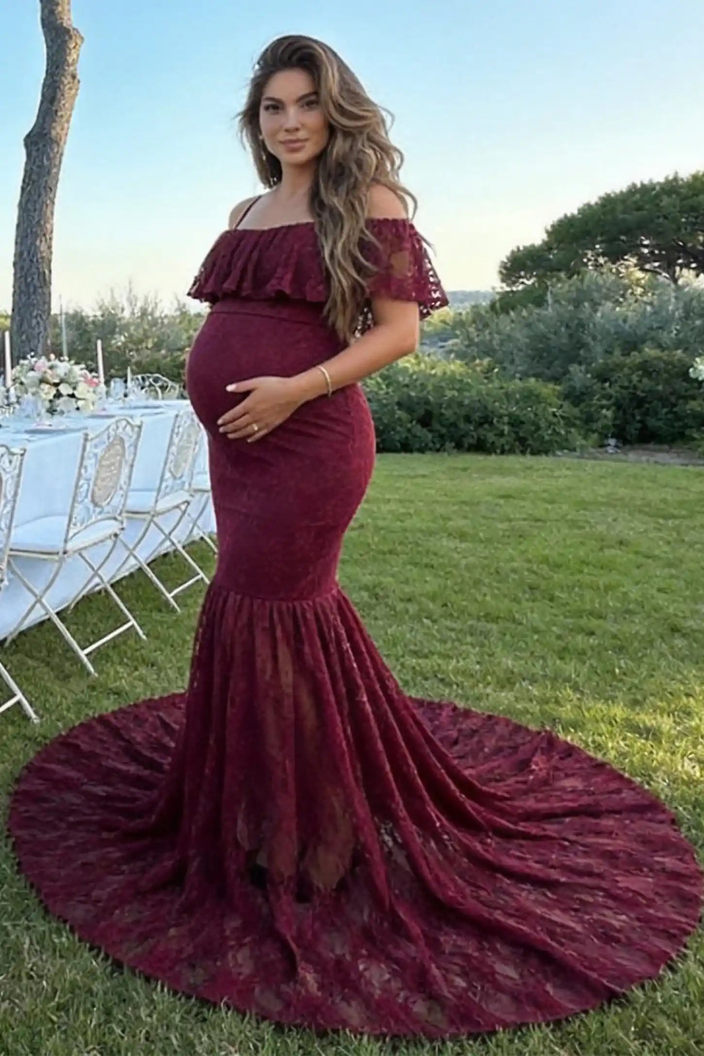 Lace Off-Shoulder Ruffle Short Sleeve Maternity Dress Lace off-shoulder maternity gown in burgundy featuring ruffle neckline, mermaid silhouette, and extended lace train on pregnant model. 