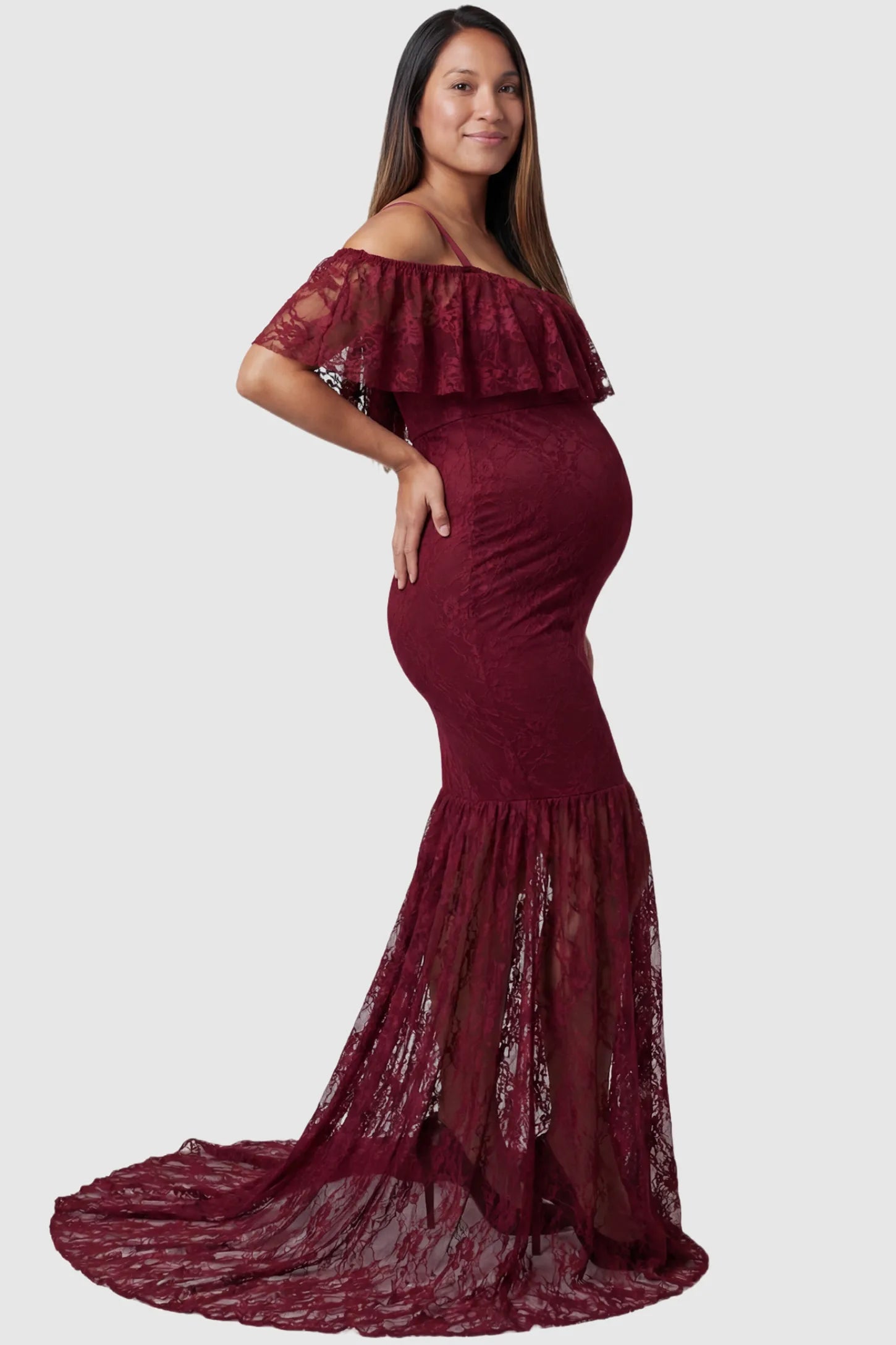 Lace Off-Shoulder Ruffle Short Sleeve Maternity Dress Lace off-shoulder maternity gown in burgundy featuring ruffle neckline, mermaid silhouette, and extended lace train on pregnant model. side view
