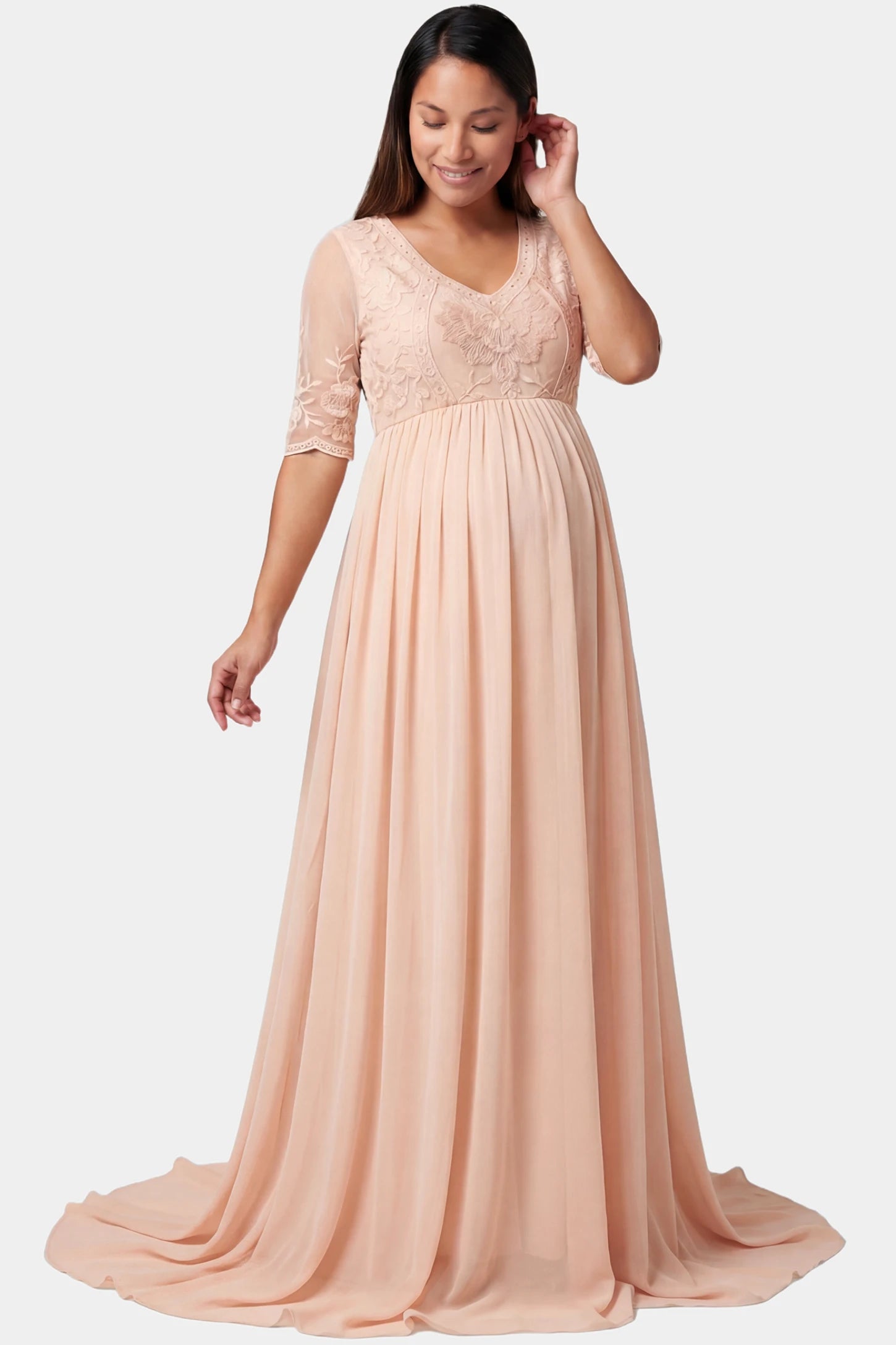 Lace Trim Long Sleeve Train Maxi Maternity Dress Lace trim half sleeve train maxi maternity dress in pink featuring lace and mesh bodice in front view on a pregnant model