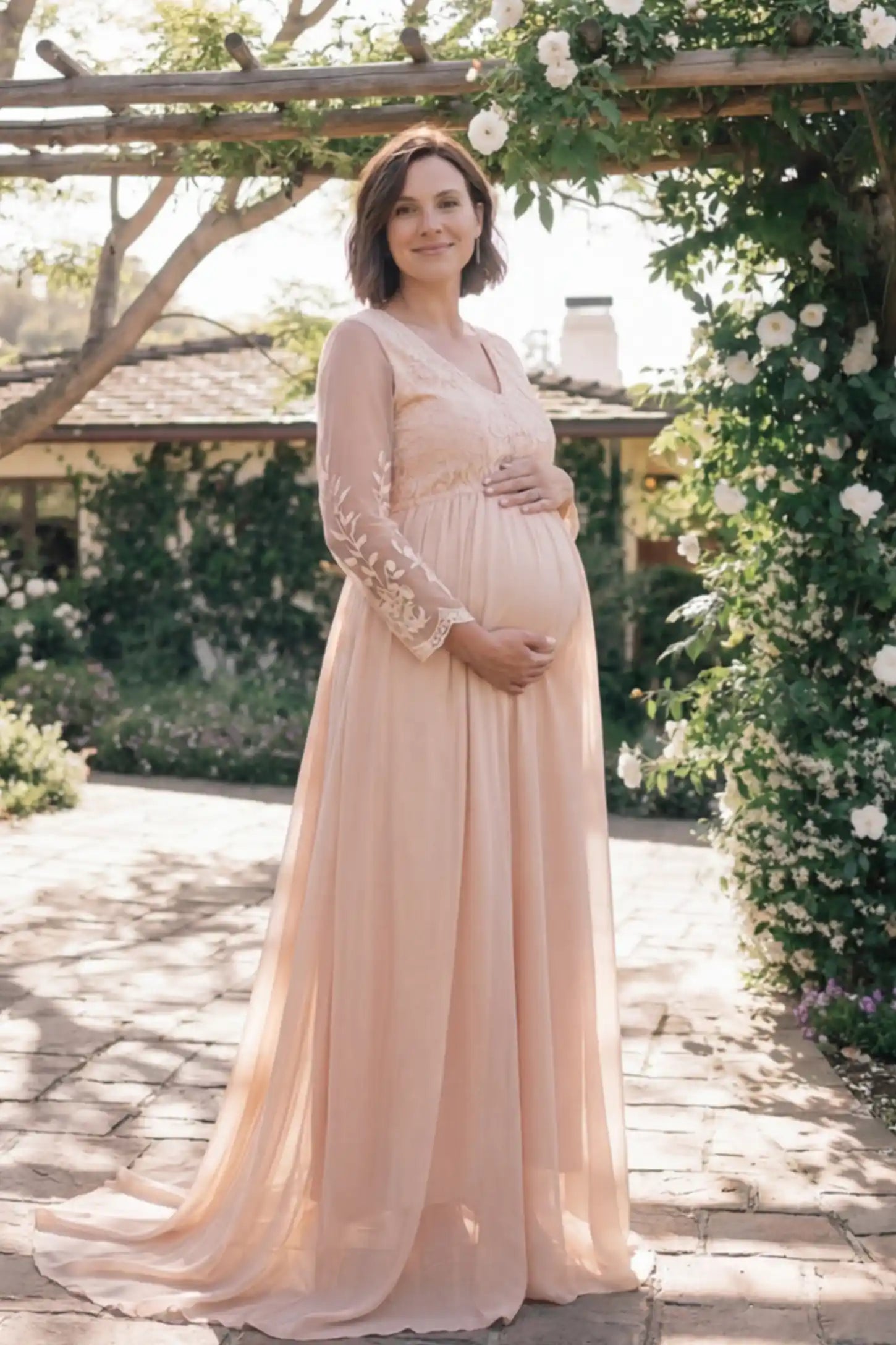 Lace Trim Long Sleeve Train Maternity Gown Lace trim long sleeve train maternity gown in pink with flowing train silhouette & mesh sleeves, front view on pregnant model