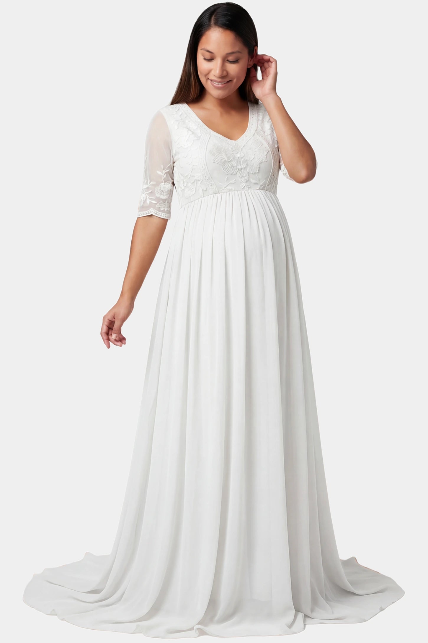 Lace trim half sleeve train maxi maternity dress in white featuring lace and mesh bodice in front view on a pregnant model