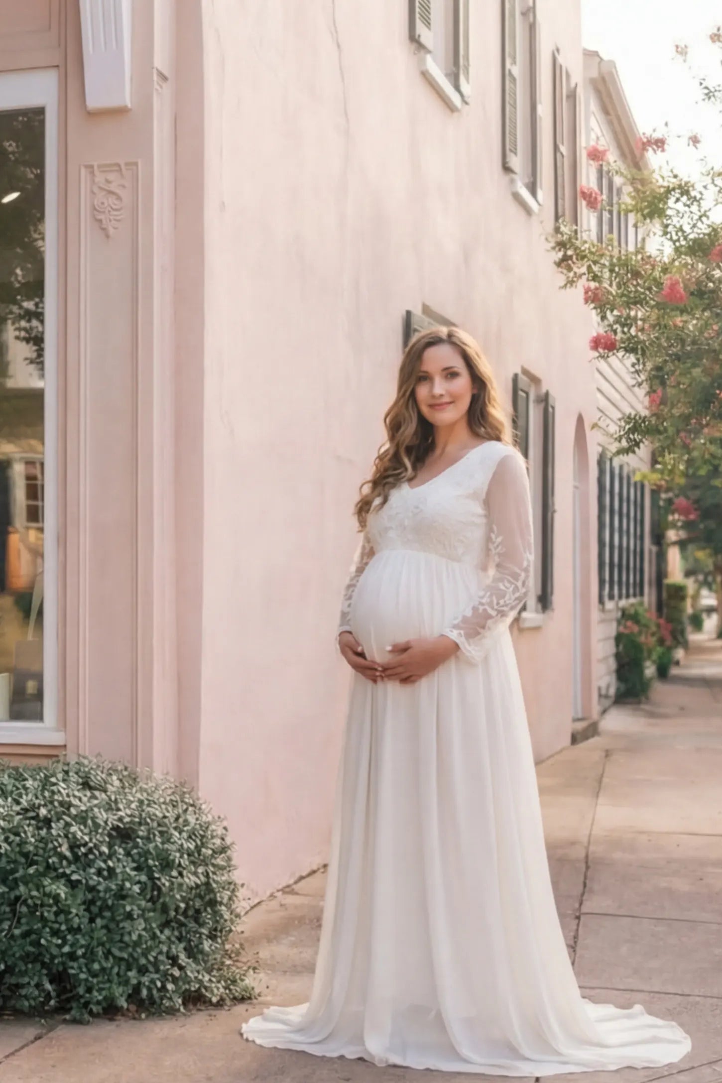 Lace Trim Long Sleeve Train Maternity Gown Lace trim long sleeve train maternity gown in white with flowing train silhouette & mesh sleeves, front view on pregnant model