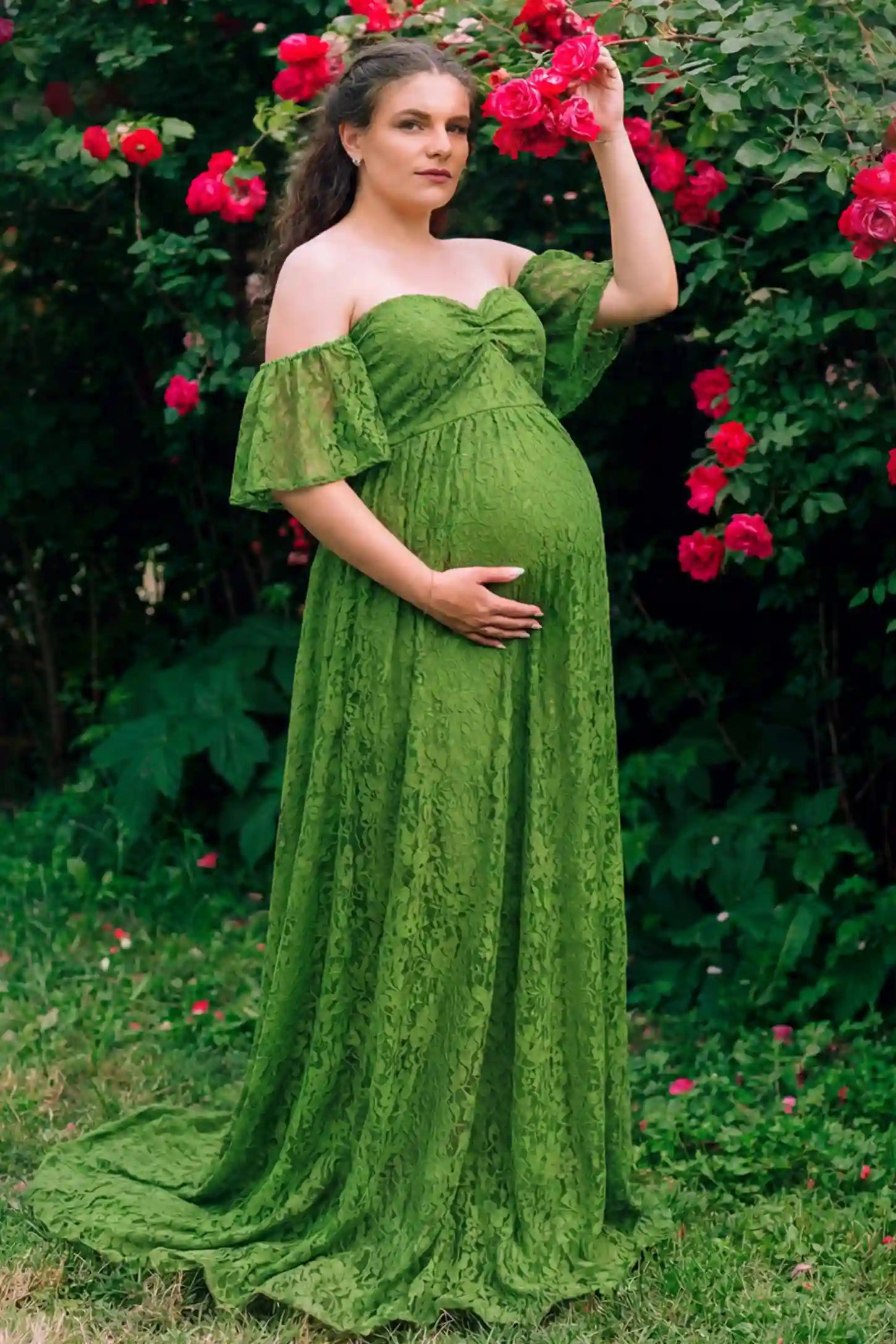 Lace Off Shoulder Maternity Maxi Dress Lace Off Shoulder Maternity Maxi Dress in apple green featuring a sweetheart neckline with a ruched bust and a full-length skirt, shown on a pregnant woman in a garden, front view.