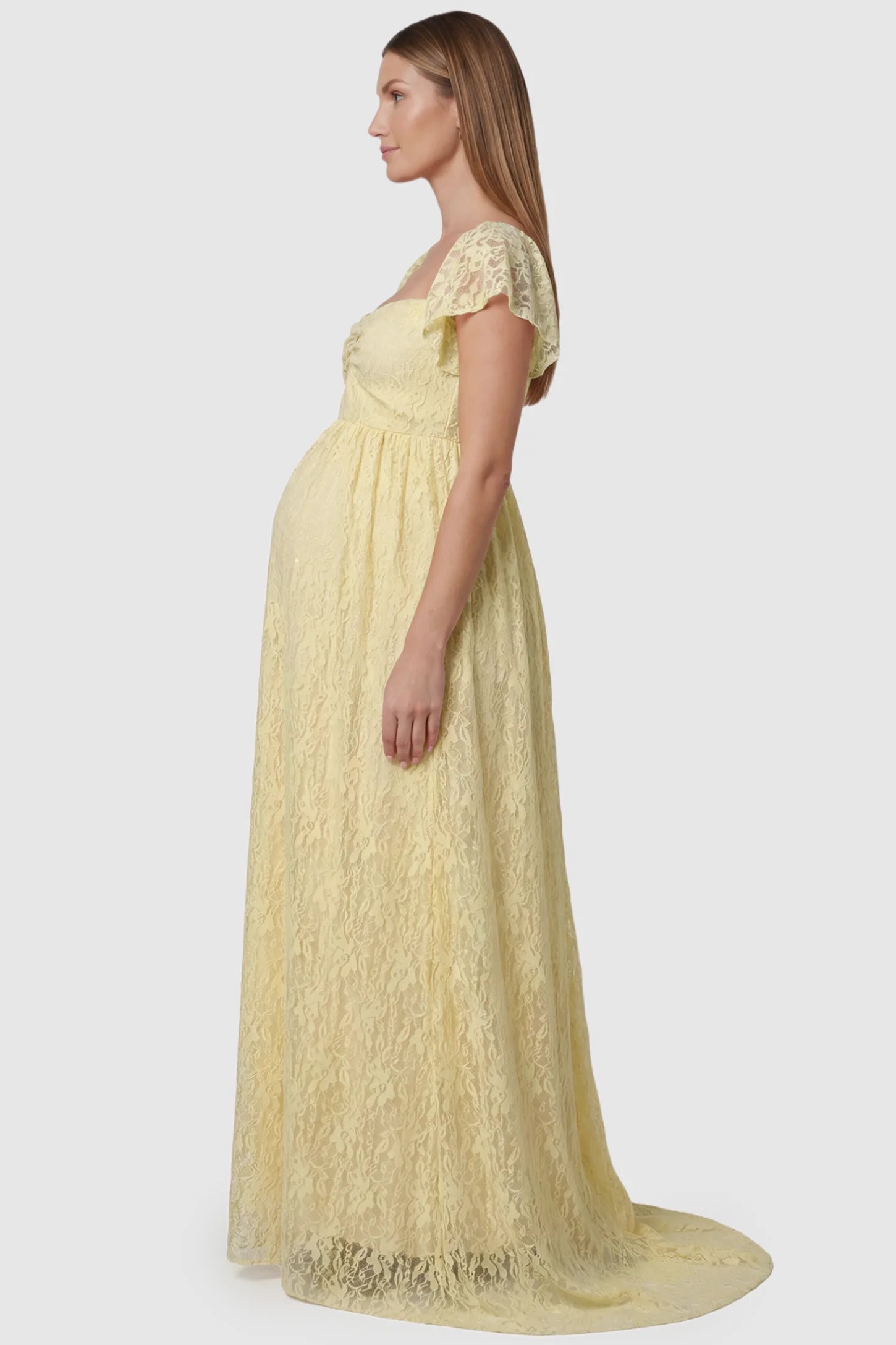 Lace Off Shoulder Maternity Maxi Dress Lace Off Shoulder Maternity Maxi Dress in apricot featuring a sweetheart neckline with a ruched bust and a full-length skirt, shown on a pregnant model, side view.
