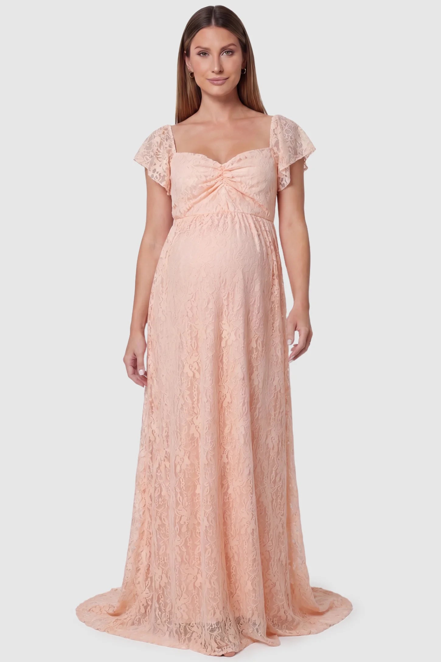 Lace Off Shoulder Maternity Maxi Dress in blush pink featuring a sweetheart neckline with a ruched bust and a full-length skirt, shown on a pregnant model, front view.